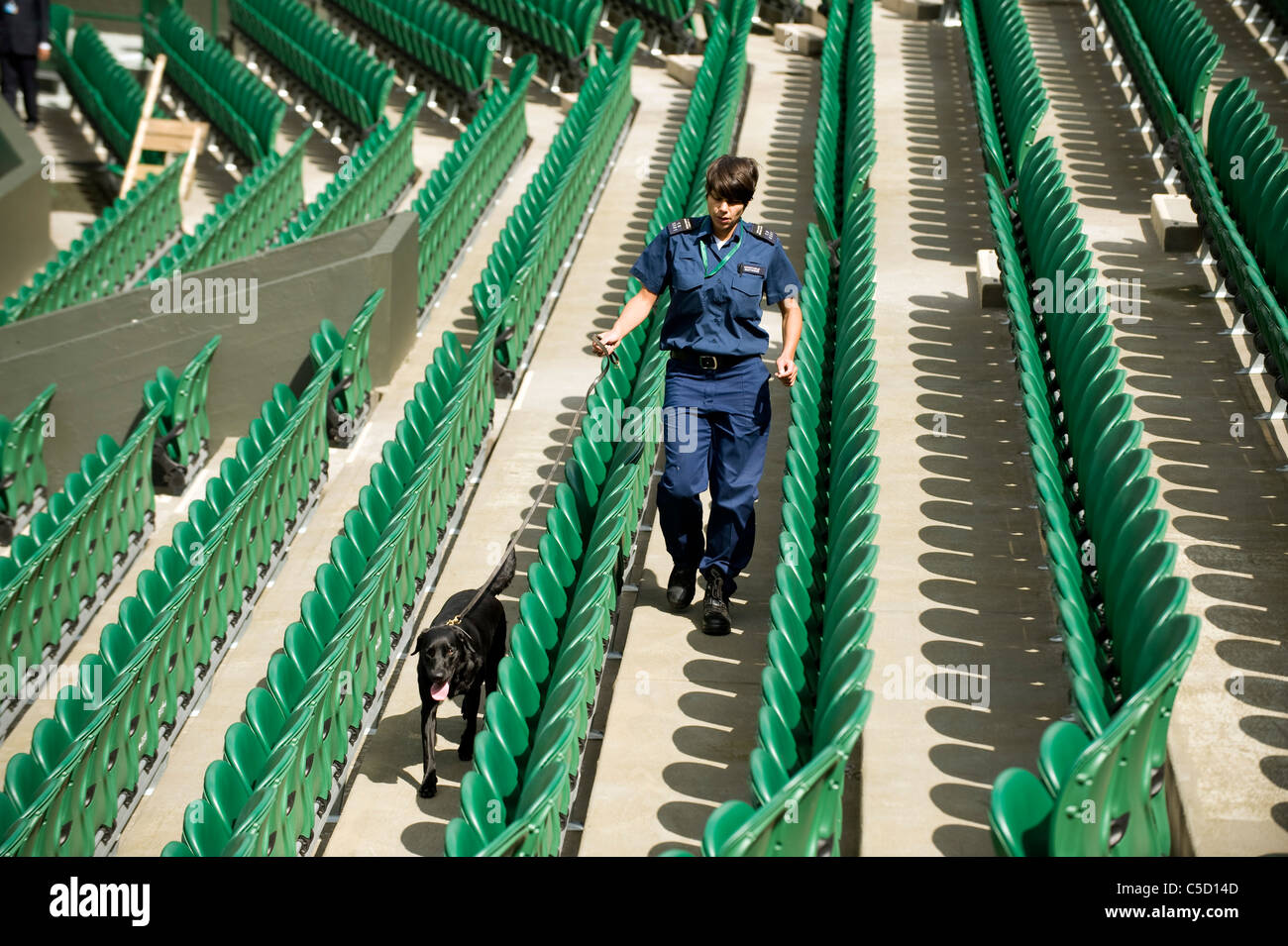 A sniffer dog and their handler work on Centre Court during the 2011