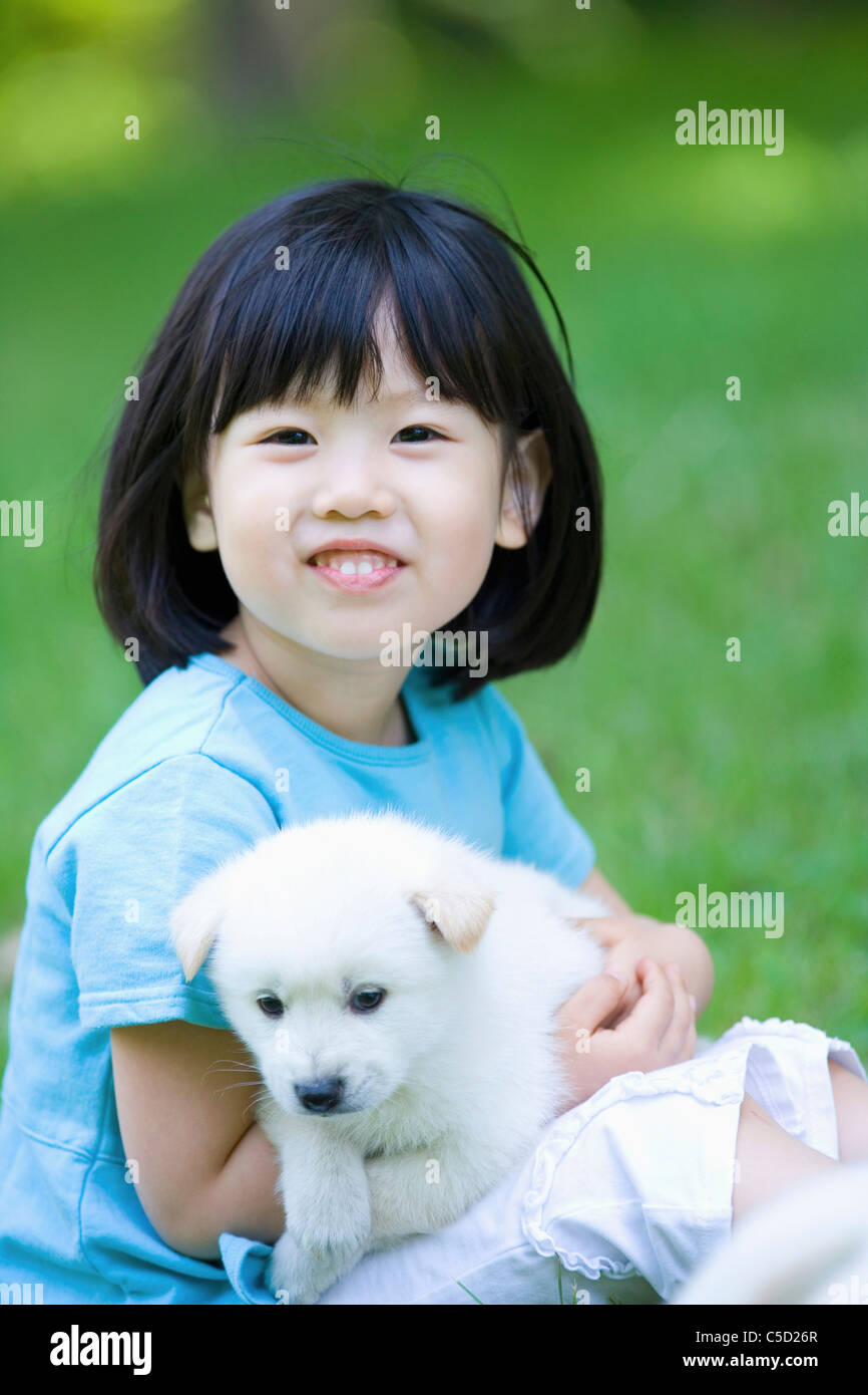 girl hugging baby dog Stock Photo