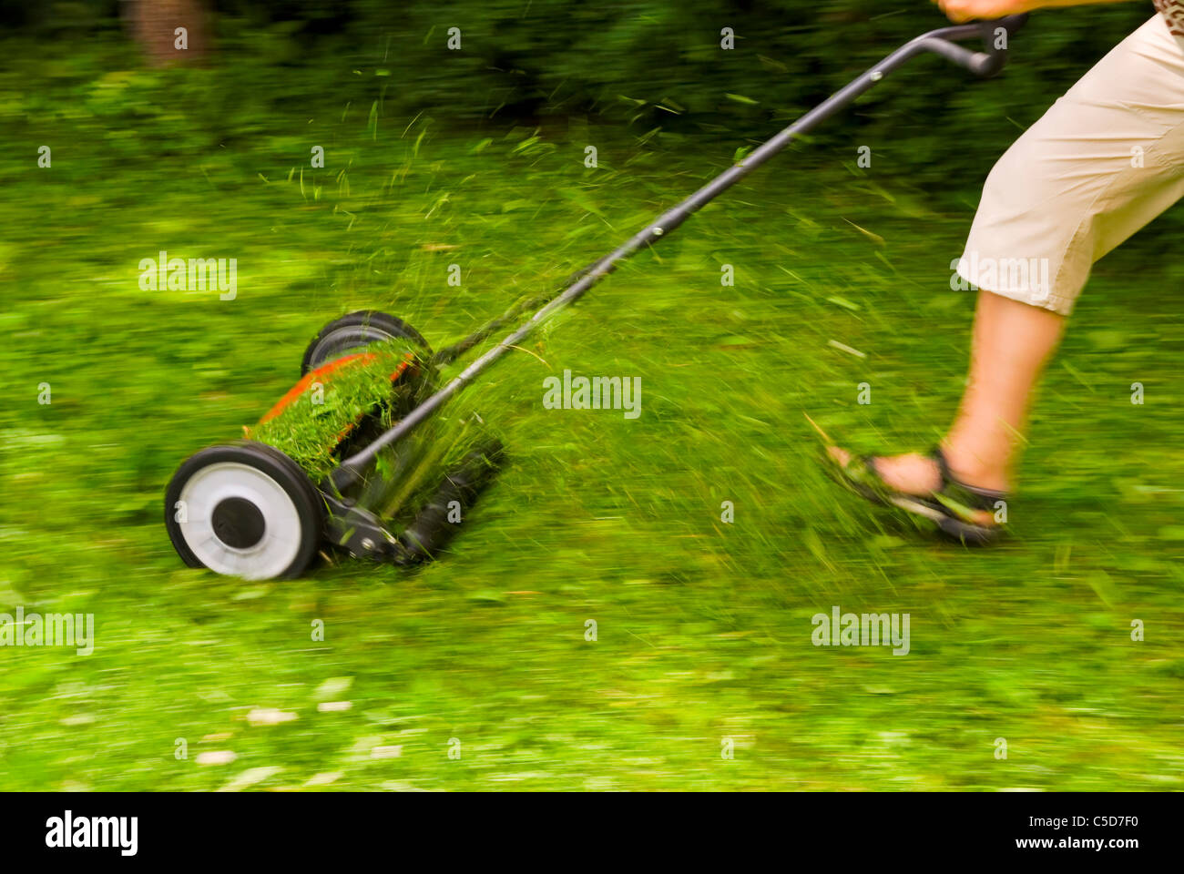 Side view of a cropped woman mowing at full speed Stock Photo