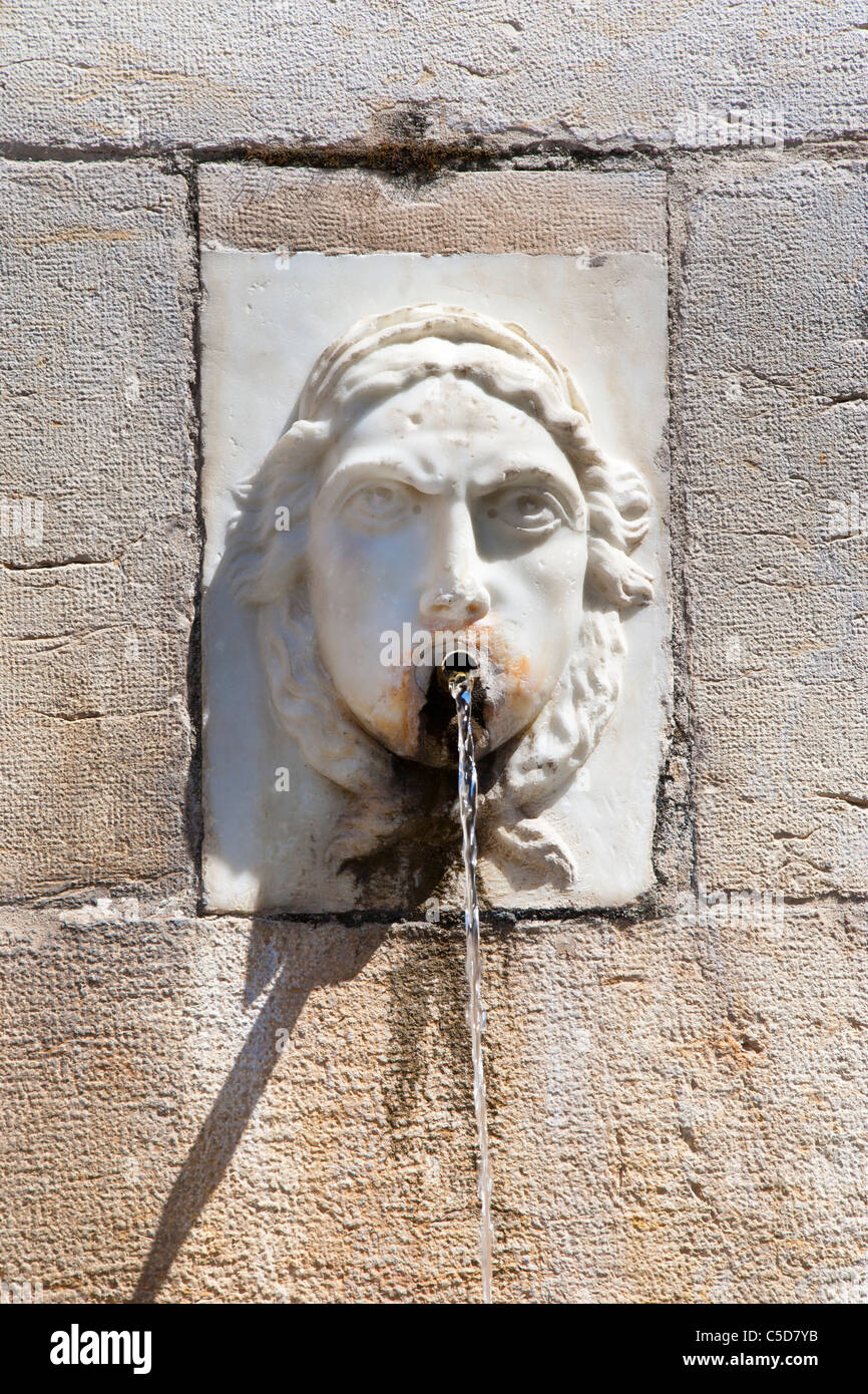 Water fountain with face at Roman gate in Antibes, Cote d'Azure, France Stock Photo