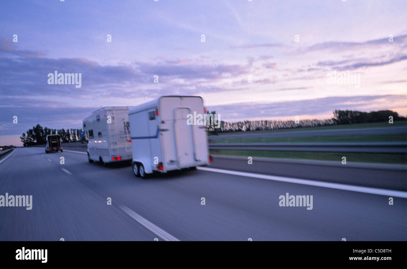 Rear shot of motorcars in full speed on the asphalt highway at dusk Stock Photo