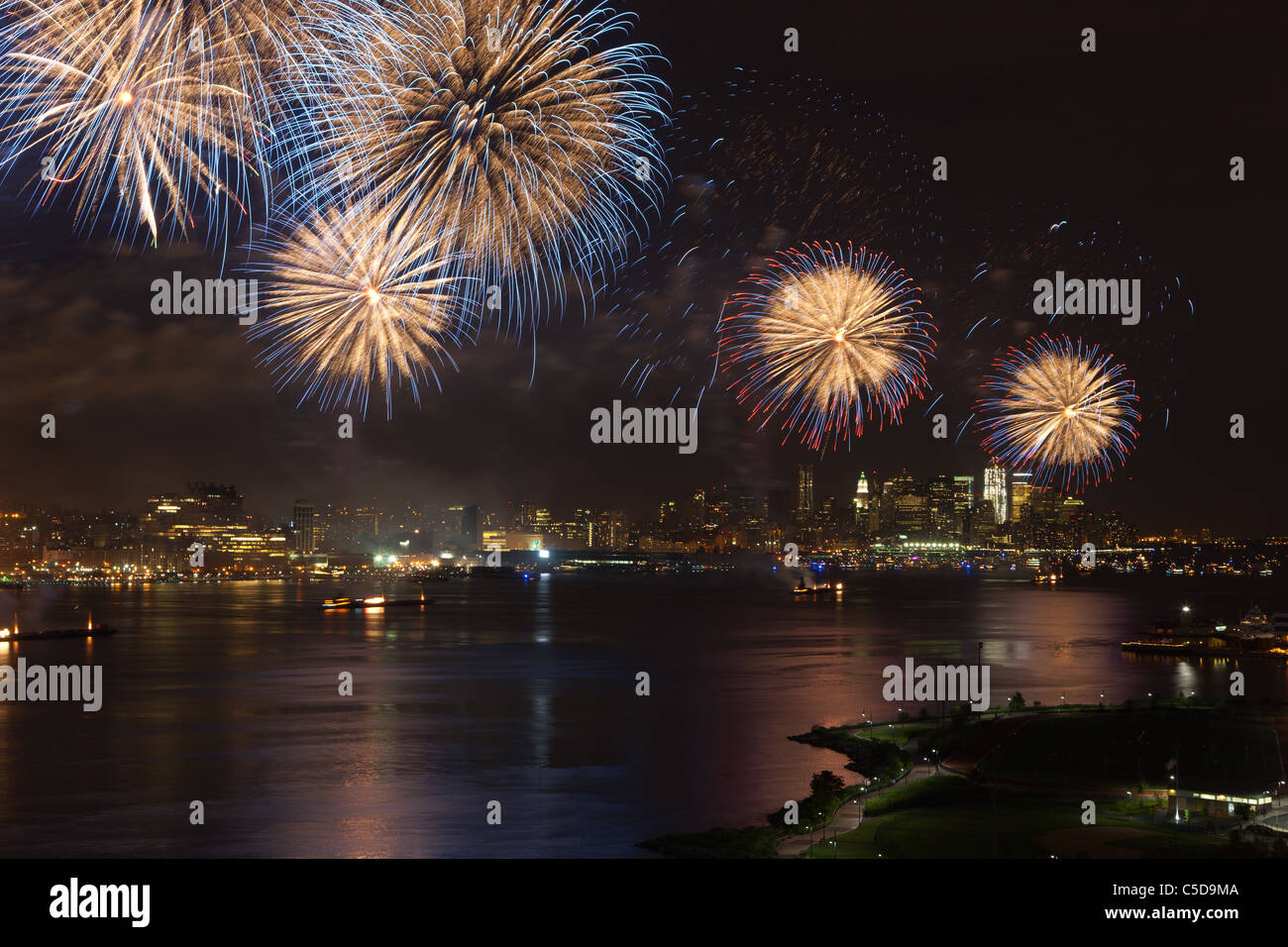 The Macy's 4th of July fireworks show lights the sky over Hudson River in New York City. Stock Photo
