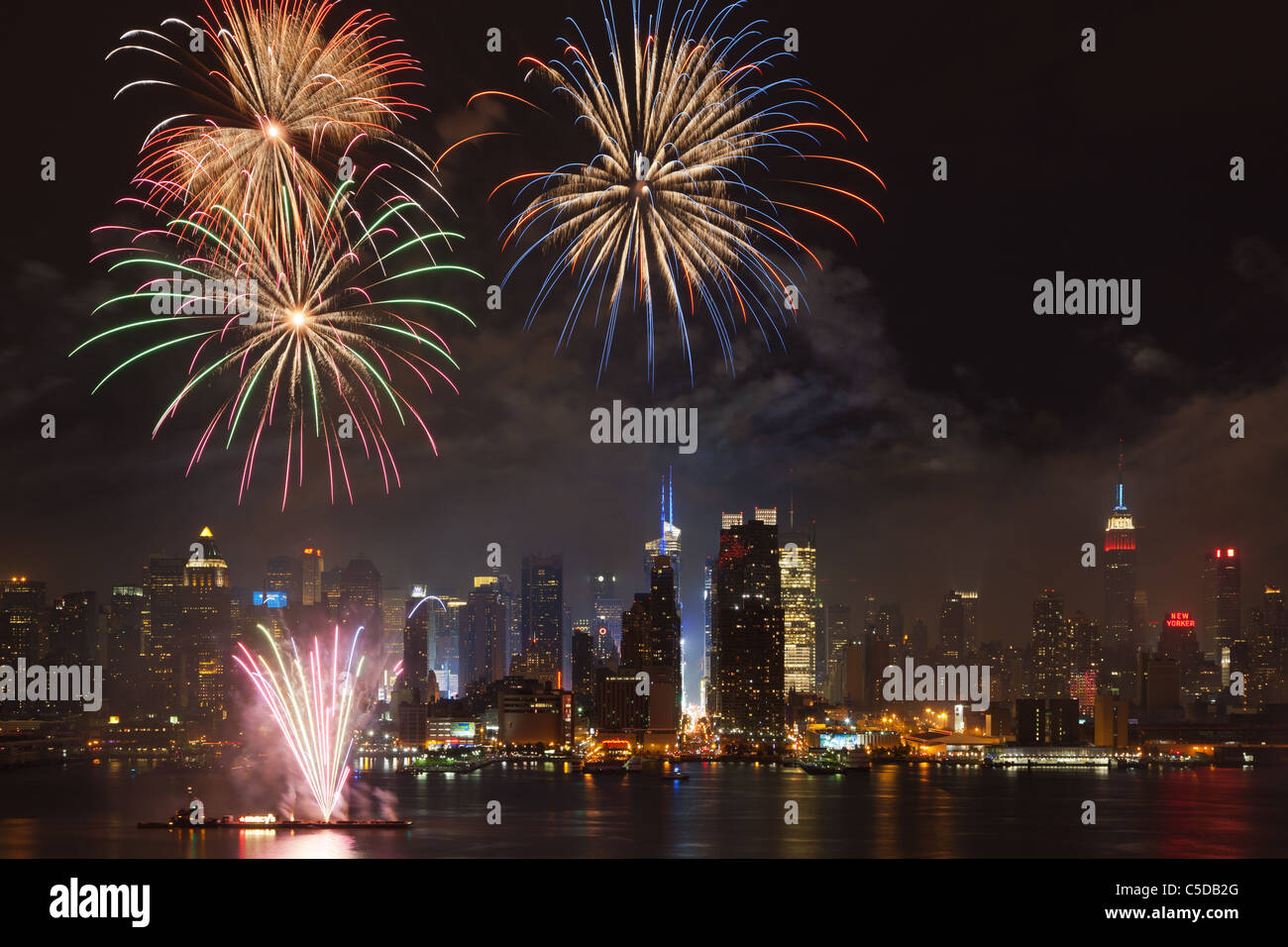 The Macy's 4th of July fireworks show lights the sky over the mid-town Manhattan skyline and Hudson River in New York City. Stock Photo