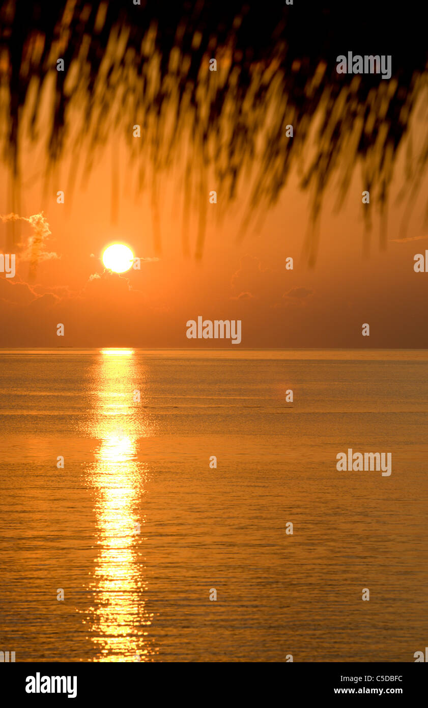 The setting sun over the tropical Indian Ocean. Coco Palm Dhuni Kolhu. Baa Atol, Maldives. Stock Photo