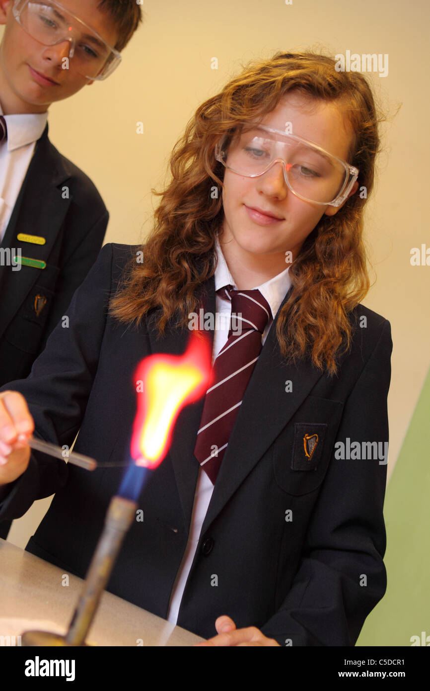 Secondary school girl student chemistry lesson with bunsen gas burner and flame test demonstration Stock Photo