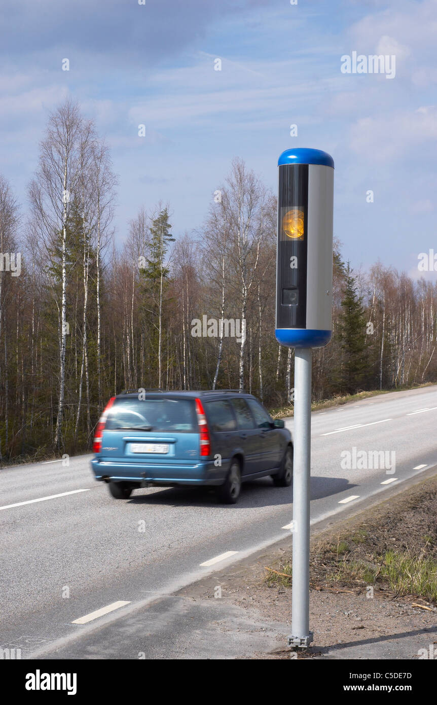 Rear shot of a car on the country asphalt road with speed camera in foreground Stock Photo