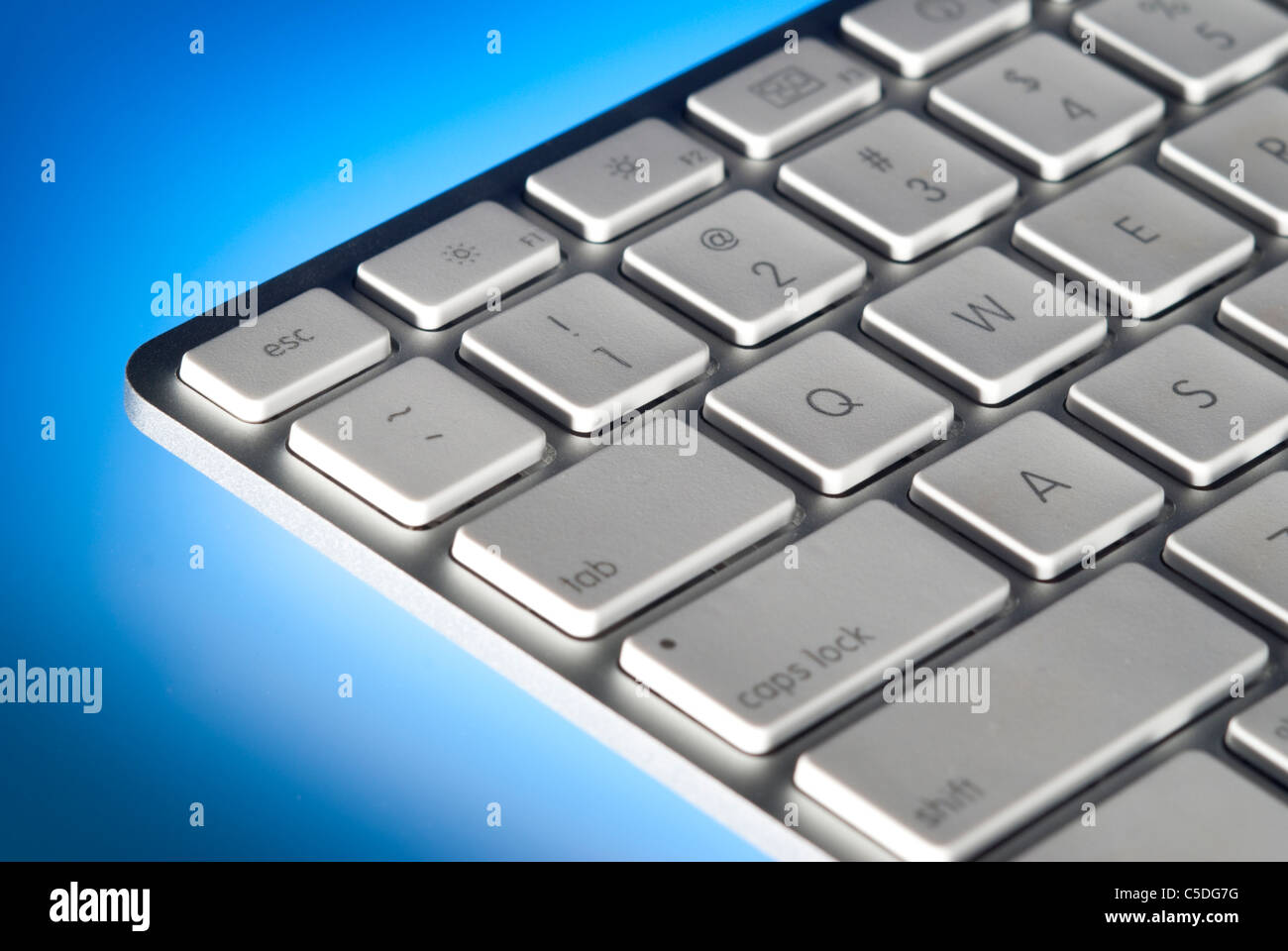 Computer keyboard close-up back lit on blue with limited depth of field Stock Photo