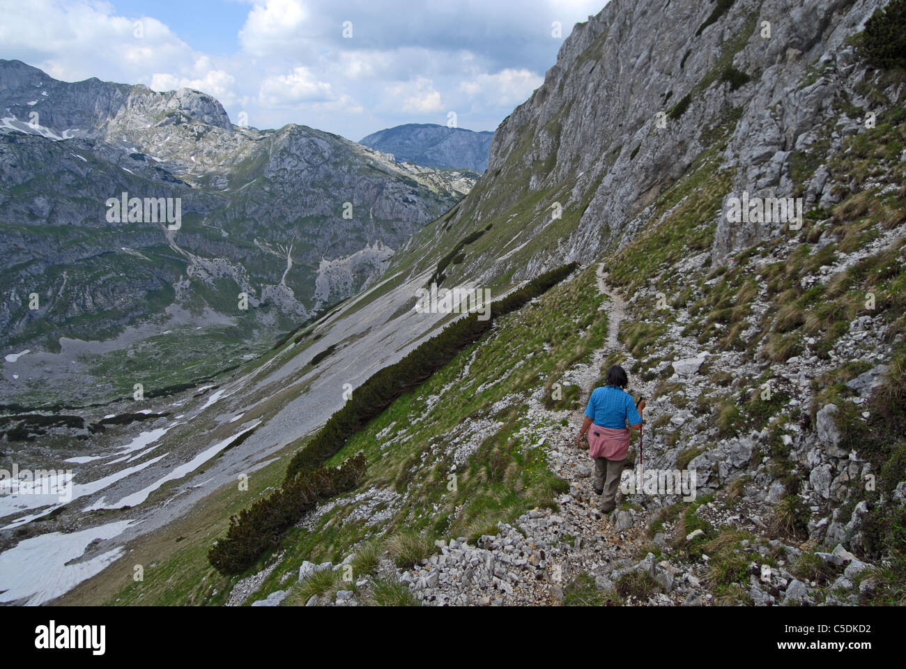 Hiker descending from Meded peak into Lokvice valley, Durmitor NP. Montenegro Stock Photo