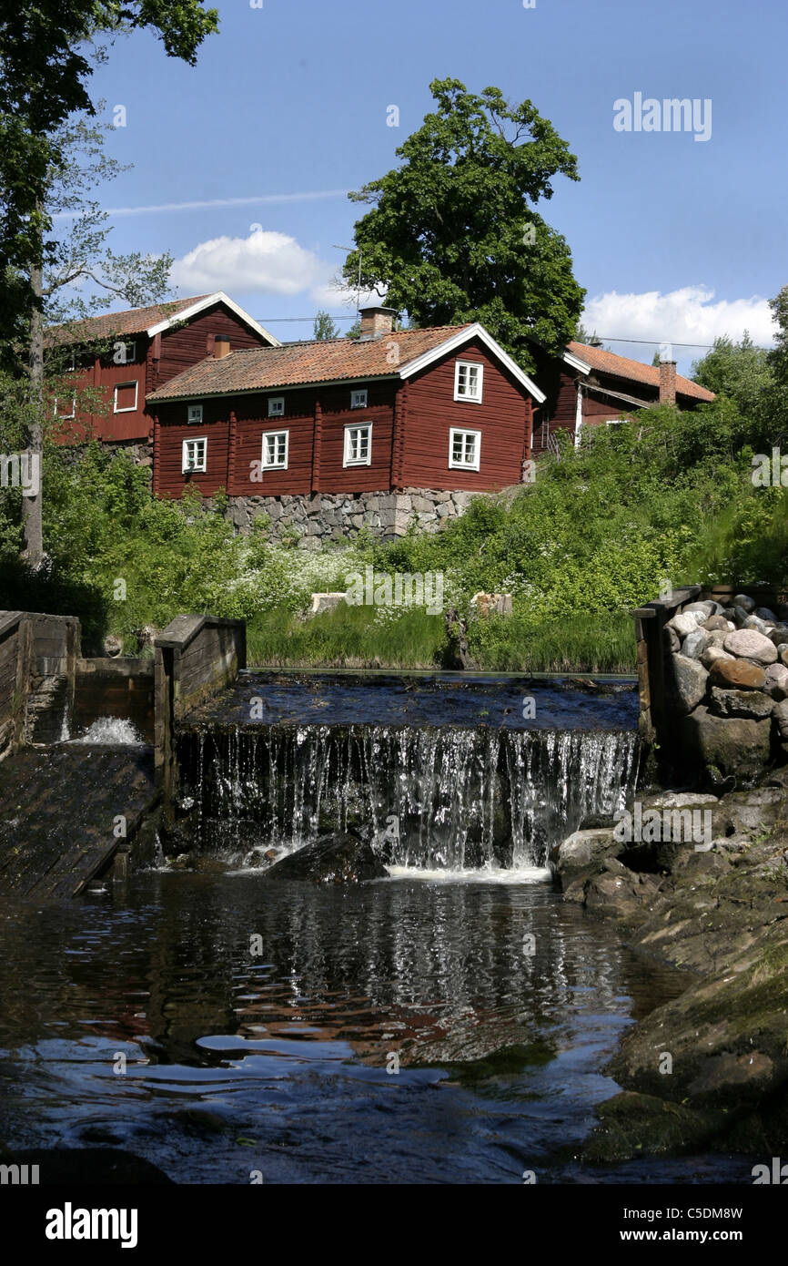 Small river with country houses against tree and blue sky at JÃ¤rle village, Sweden Stock Photo