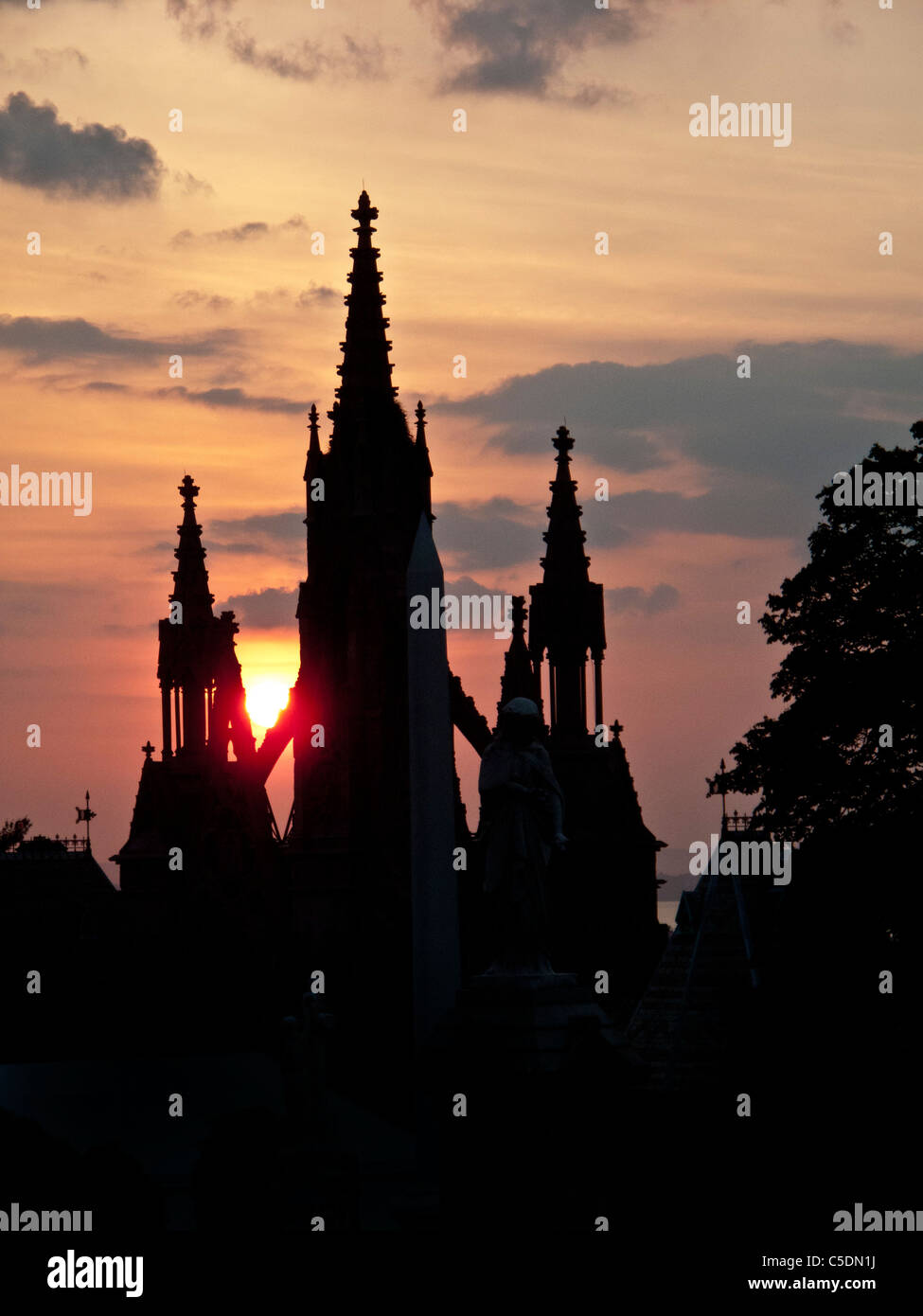 Sun sets over the Gothic Revival gates of Green-Wood Cemetery in Brooklyn, New York. Stock Photo