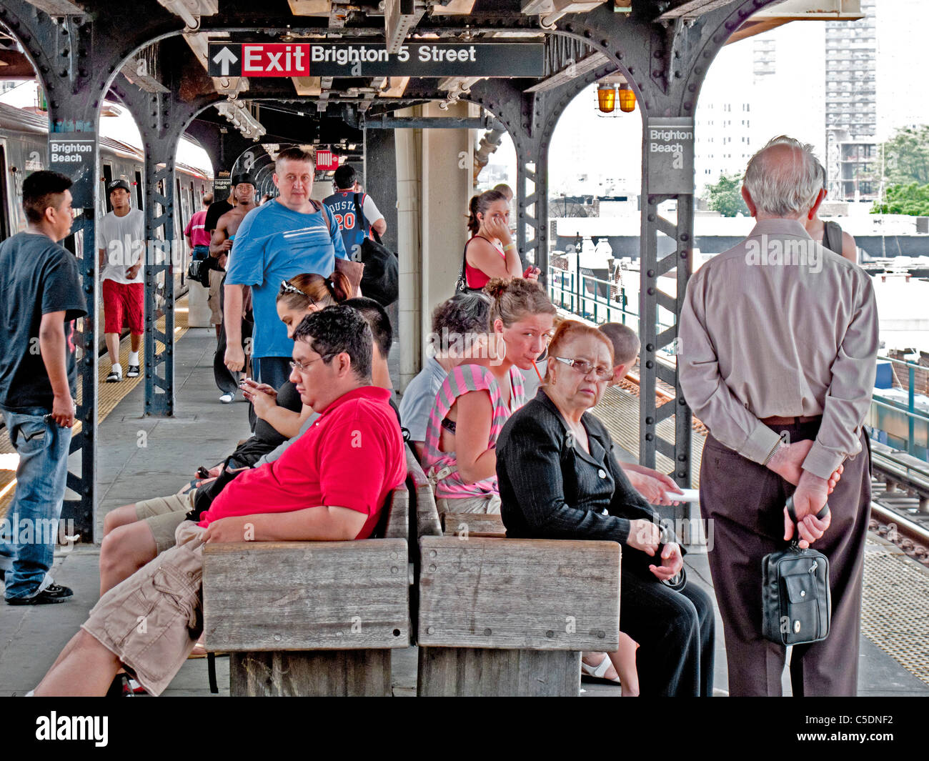 Passengers wait for a subway train at an elevated platform in the Brighton Beach neighborhood of Brooklyn, New York. Stock Photo