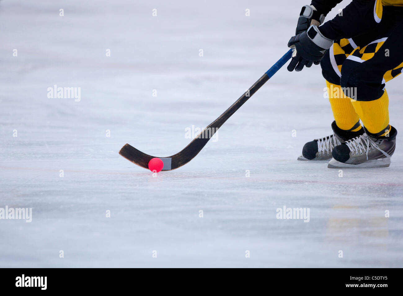 Side view low section of bandy on ice in motion Stock Photo