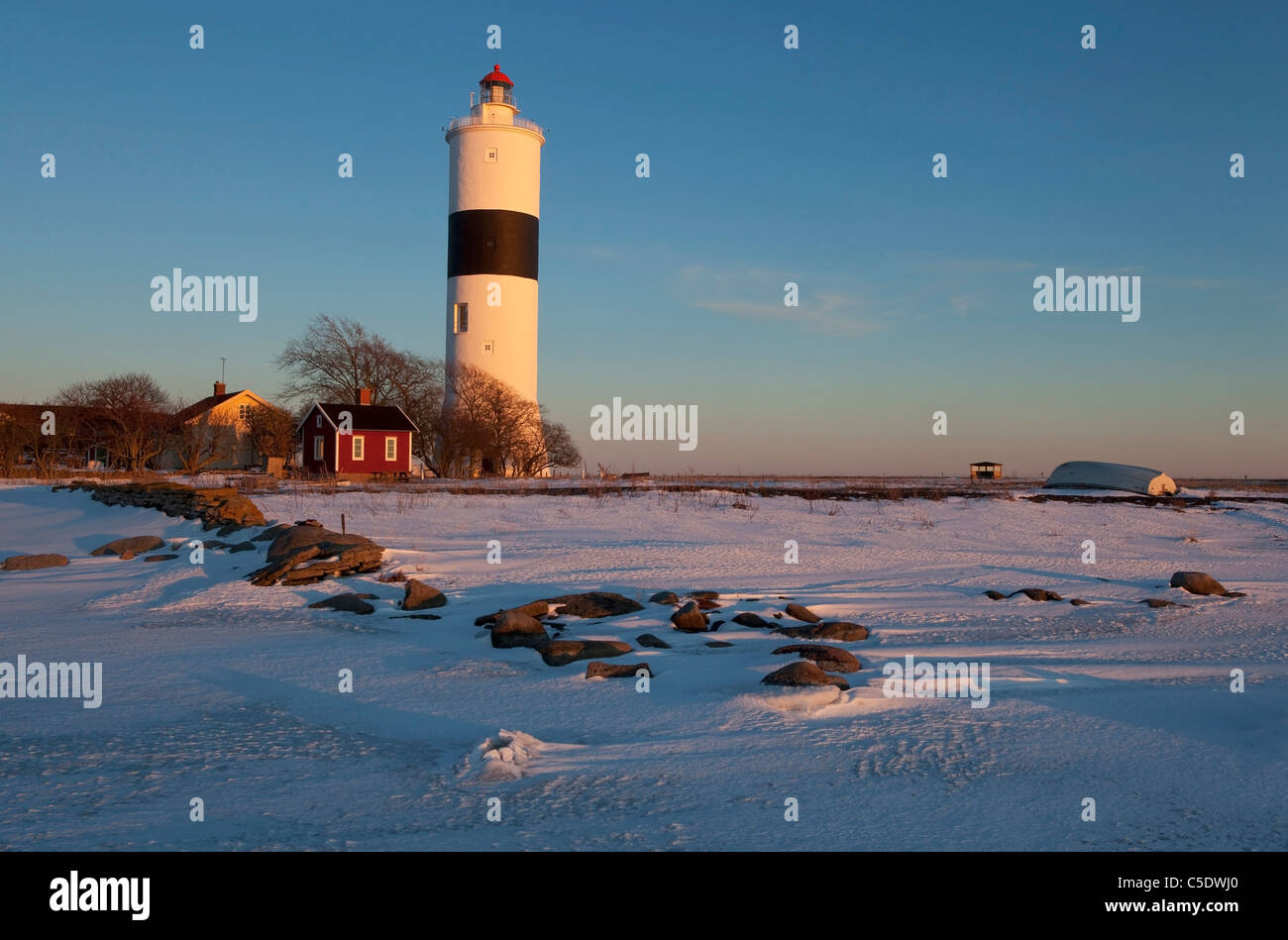 The lighthouse against clear blue sky with peaceful snowed land in foreground at Oland, Sweden Stock Photo
