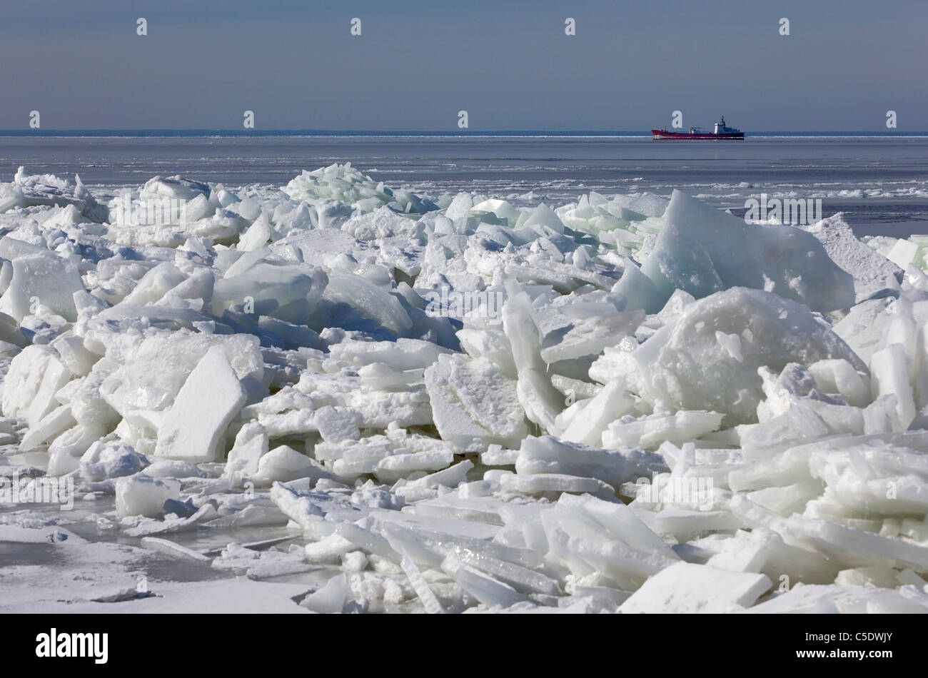 Ship at a distance in the Baltic sea against sky with ice blocks in foreground Stock Photo
