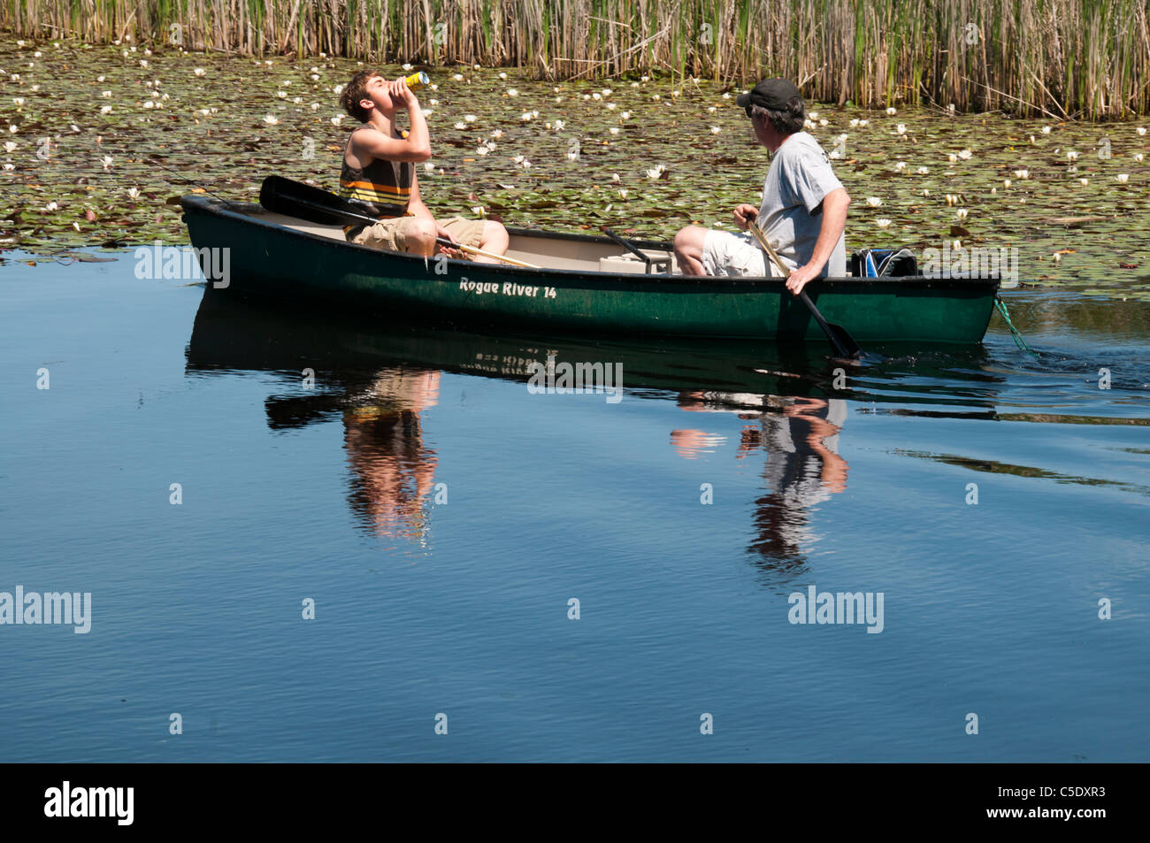 Two men in green canoe. Stock Photo