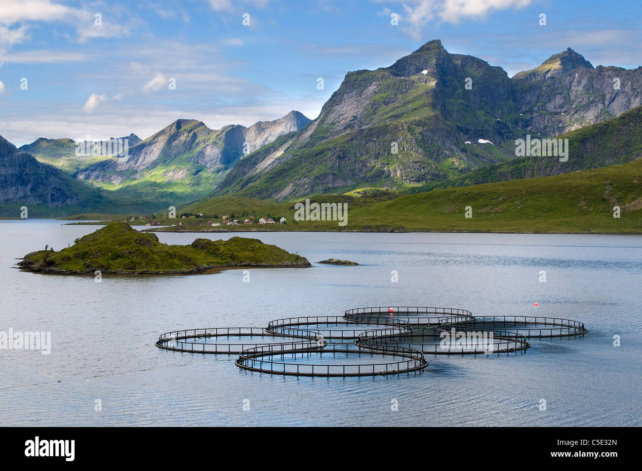 View of fish farming in peaceful sea against mountain landscape at Lofoten, Norway Stock Photo