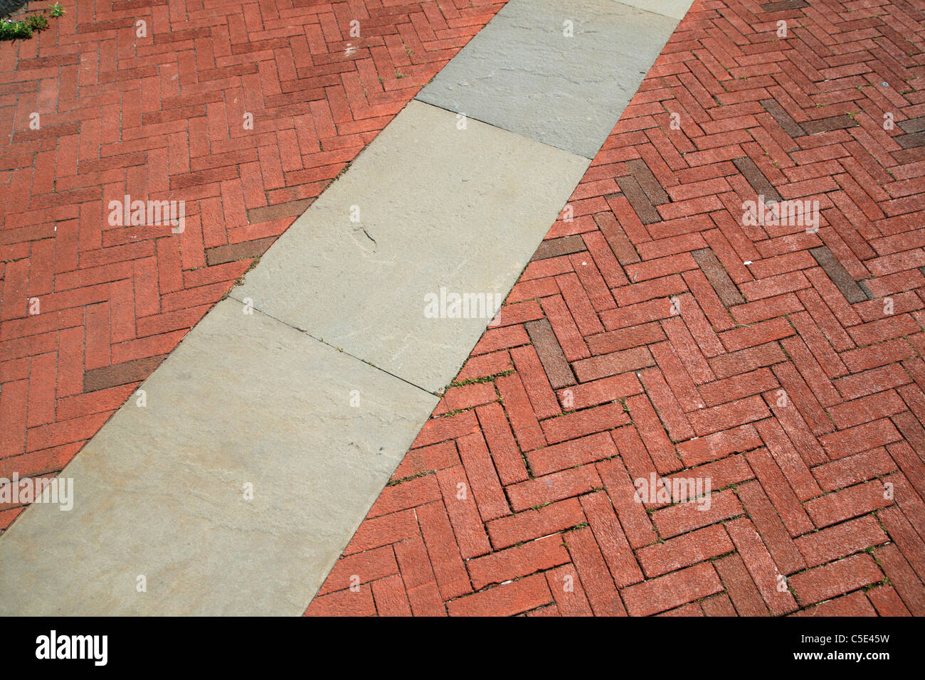 red herringbone brick and gray sand stone walkway Stock Photo