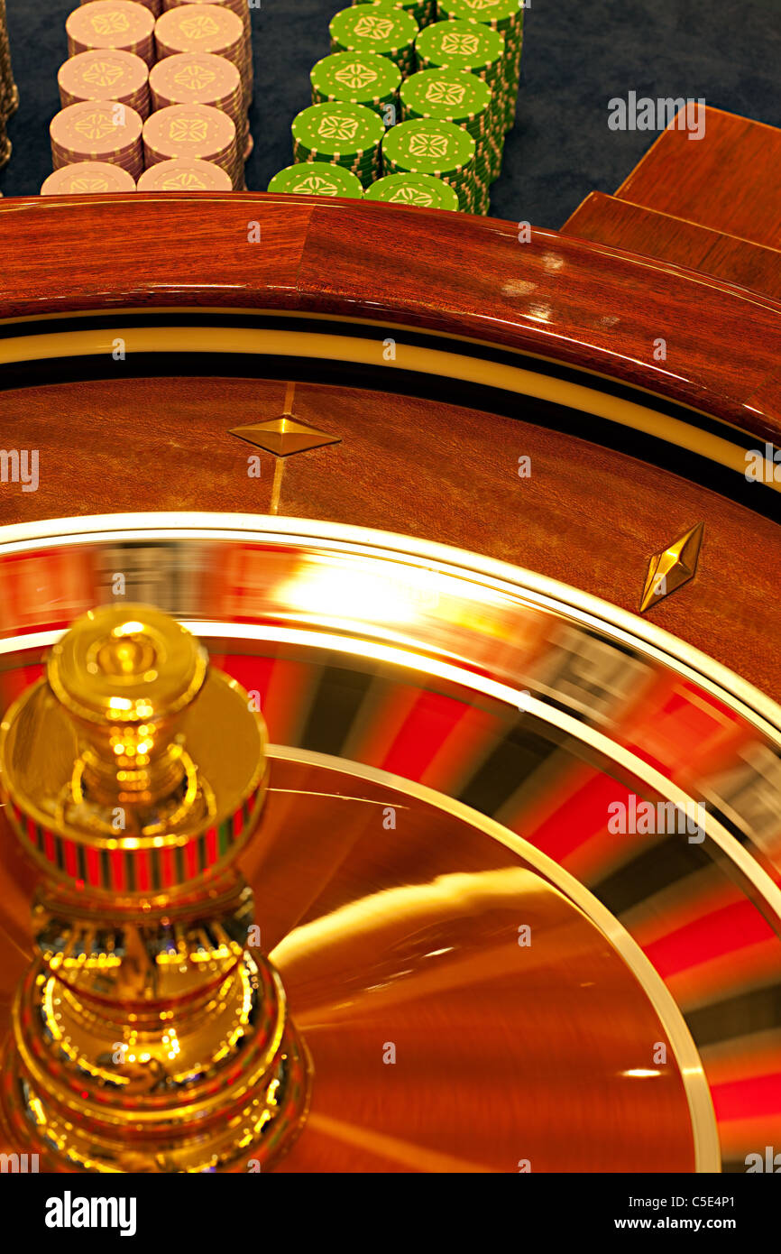 detail of a roulette wheel spinning, with betting chips behind Stock