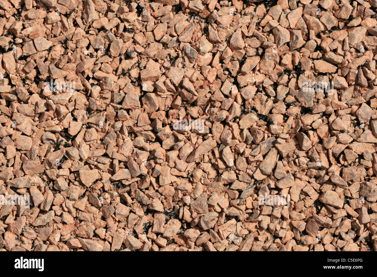 pink gravel on a freshly paved road Stock Photo