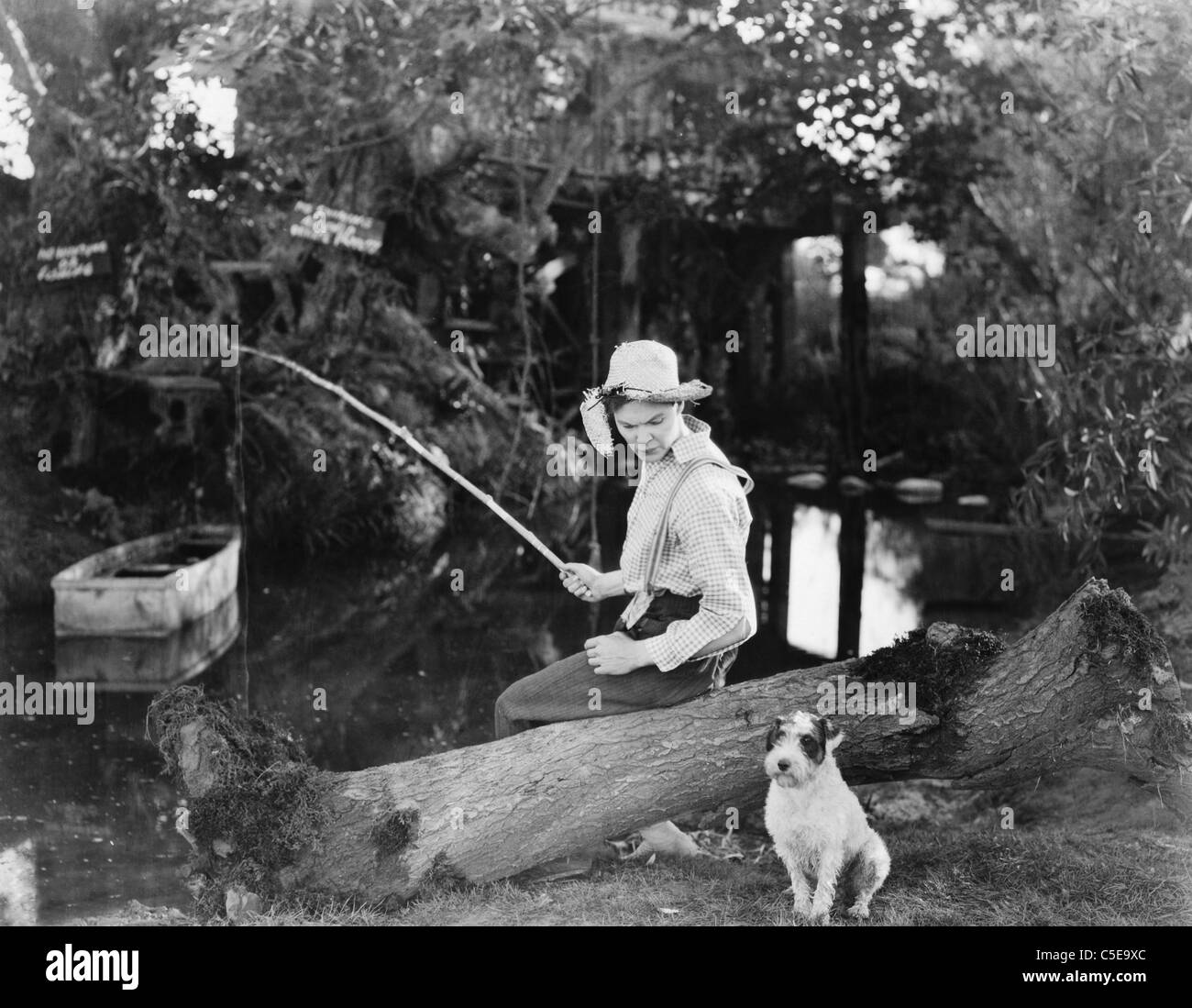 Young man fishing with his dog Stock Photo