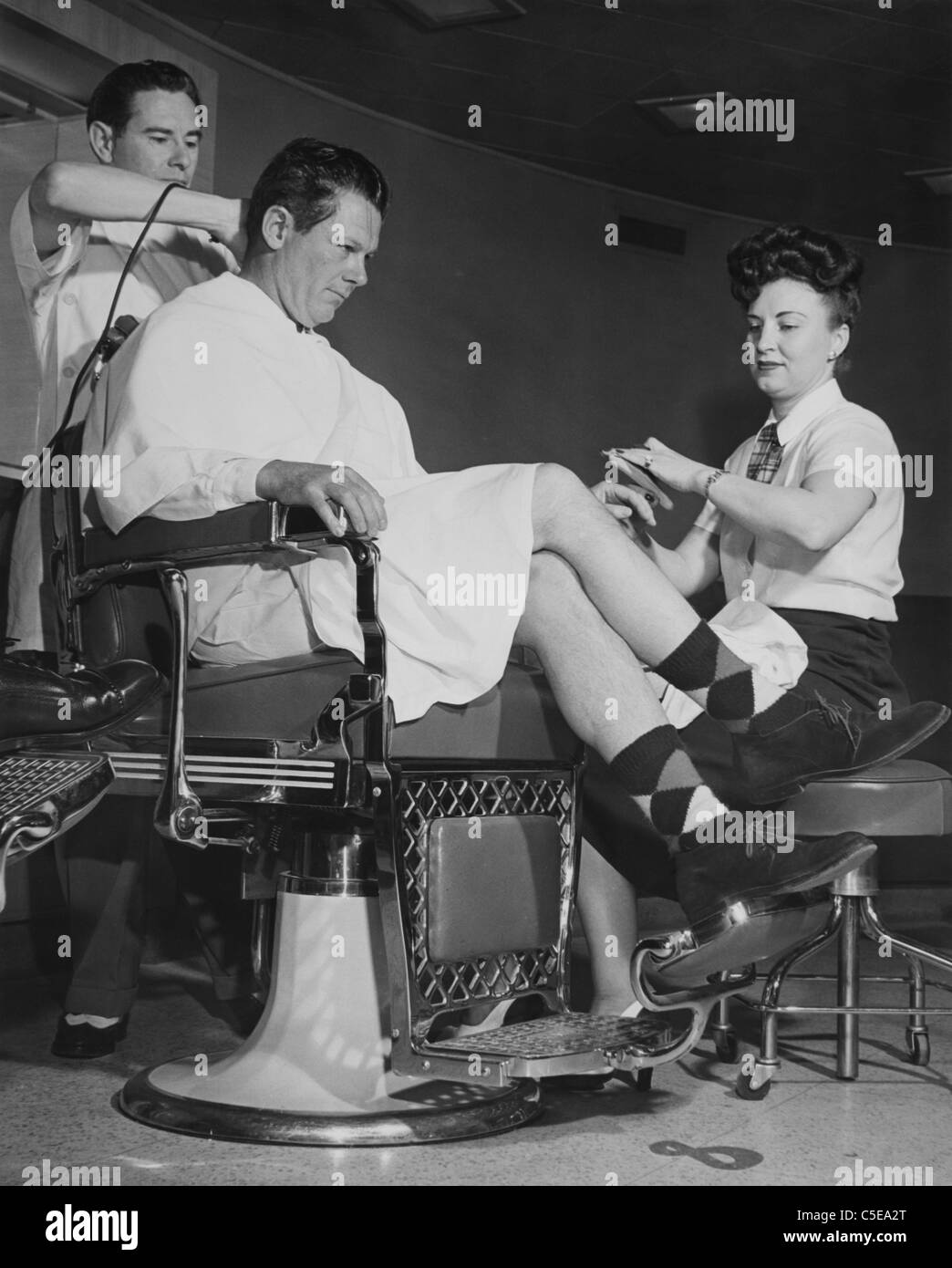 Man getting his hair cut and nails manicured Stock Photo