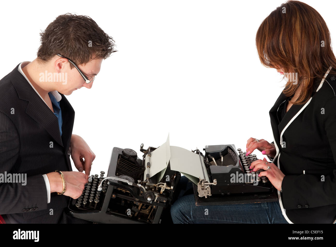 Couple is typing at the old fashioned black typewriters Stock Photo