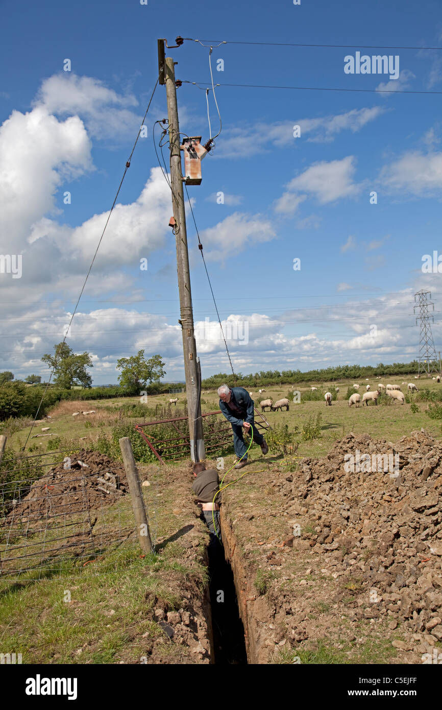 Western Power engineer installing earth cable in trench from elecricity