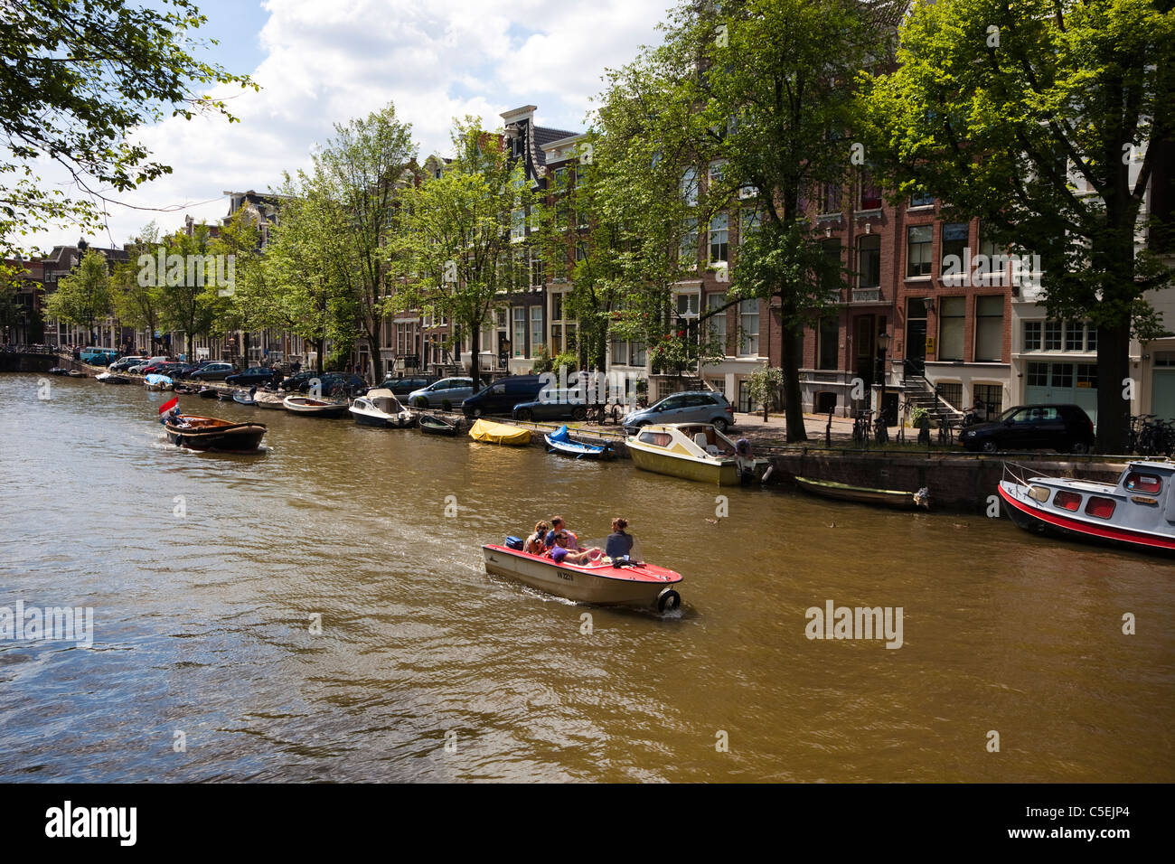 Small motor boats sailing on a canal, Amsterdam, Holland Stock Photo