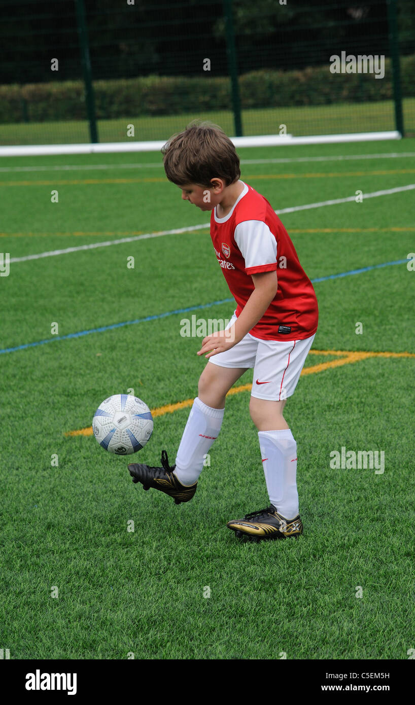 Young footballer in control of the ball on a Astra Turf pitch