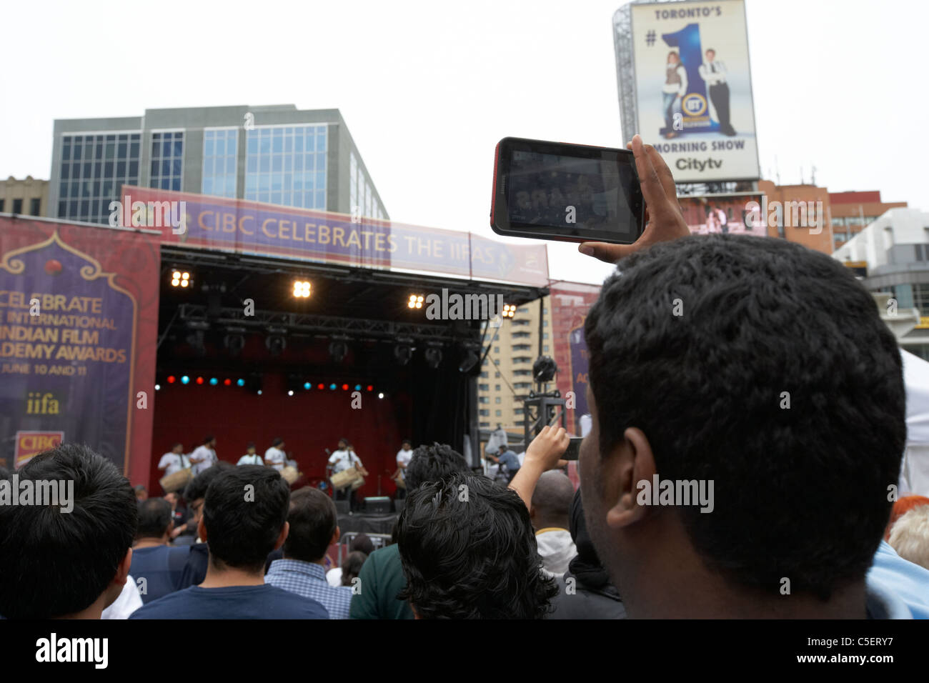 man taking photos and video with a tablet computer at an outdoor event toronto ontario canada Stock Photo