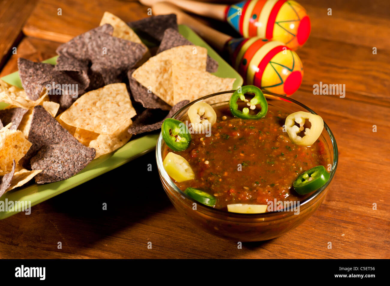 Homemade Salsa with blue and plain corn chips, sliced Jalapeños