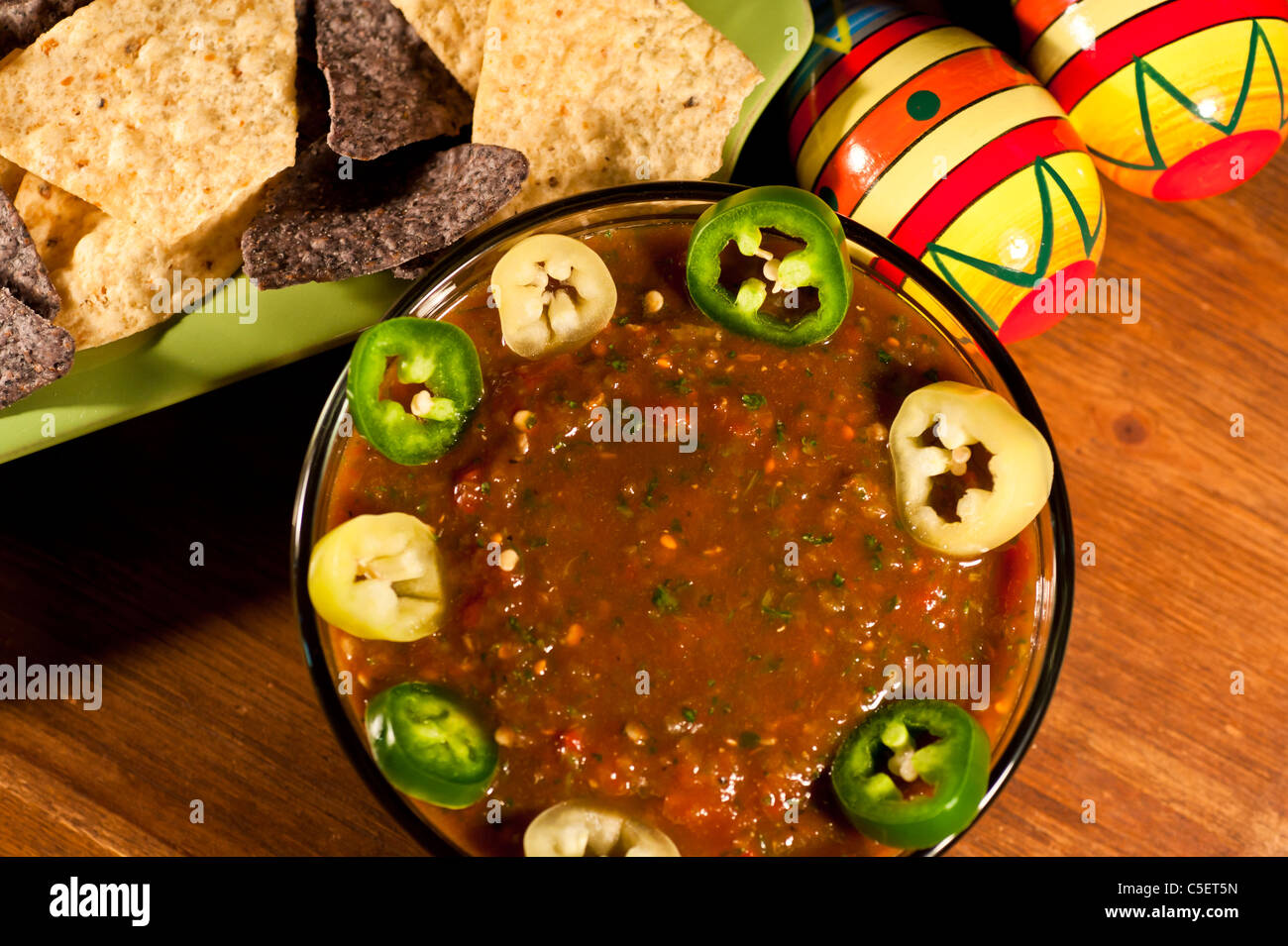 Homemade Salsa with blue and plain corn chips, sliced Jalapeños