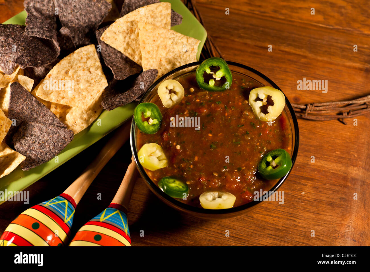 Homemade Salsa with blue and plain corn chips, sliced Jalapeños