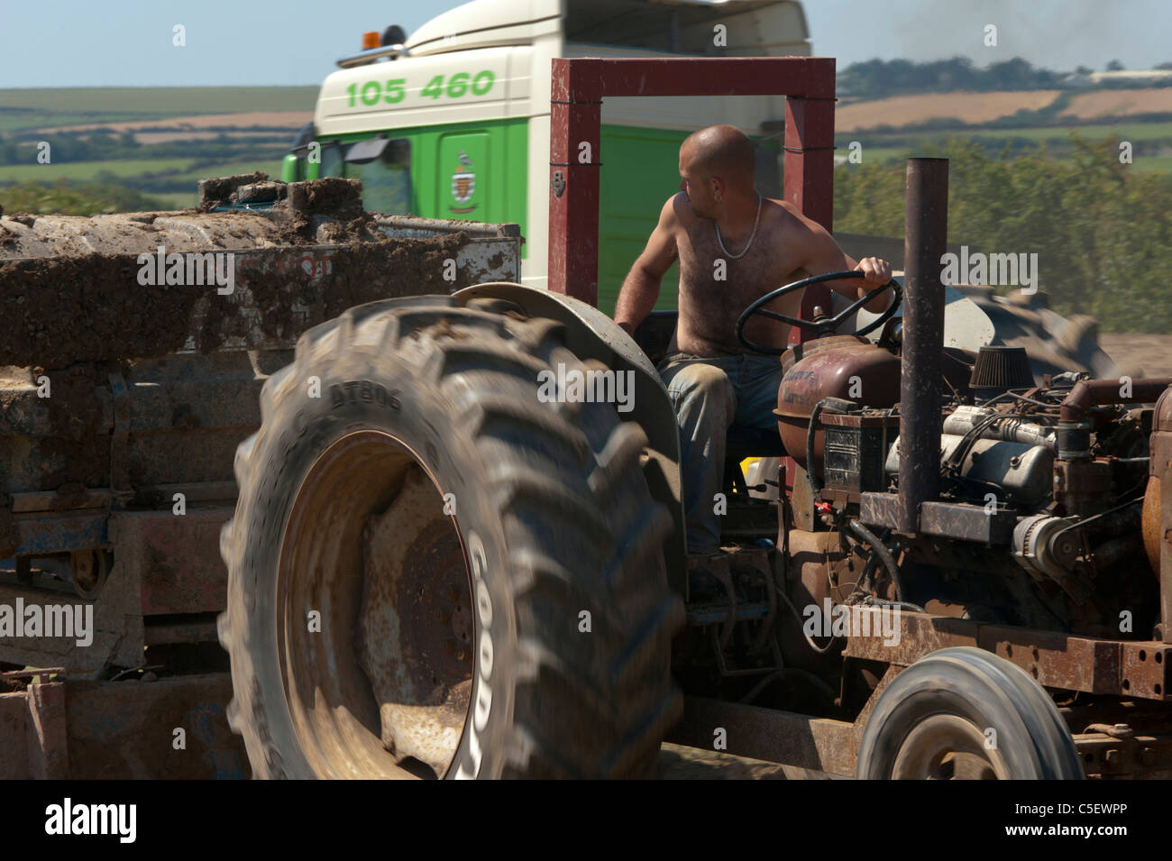 A tractor pulling the sleigh with driver looking over his shoulder in a field near Padstow Cornwall Stock Photo