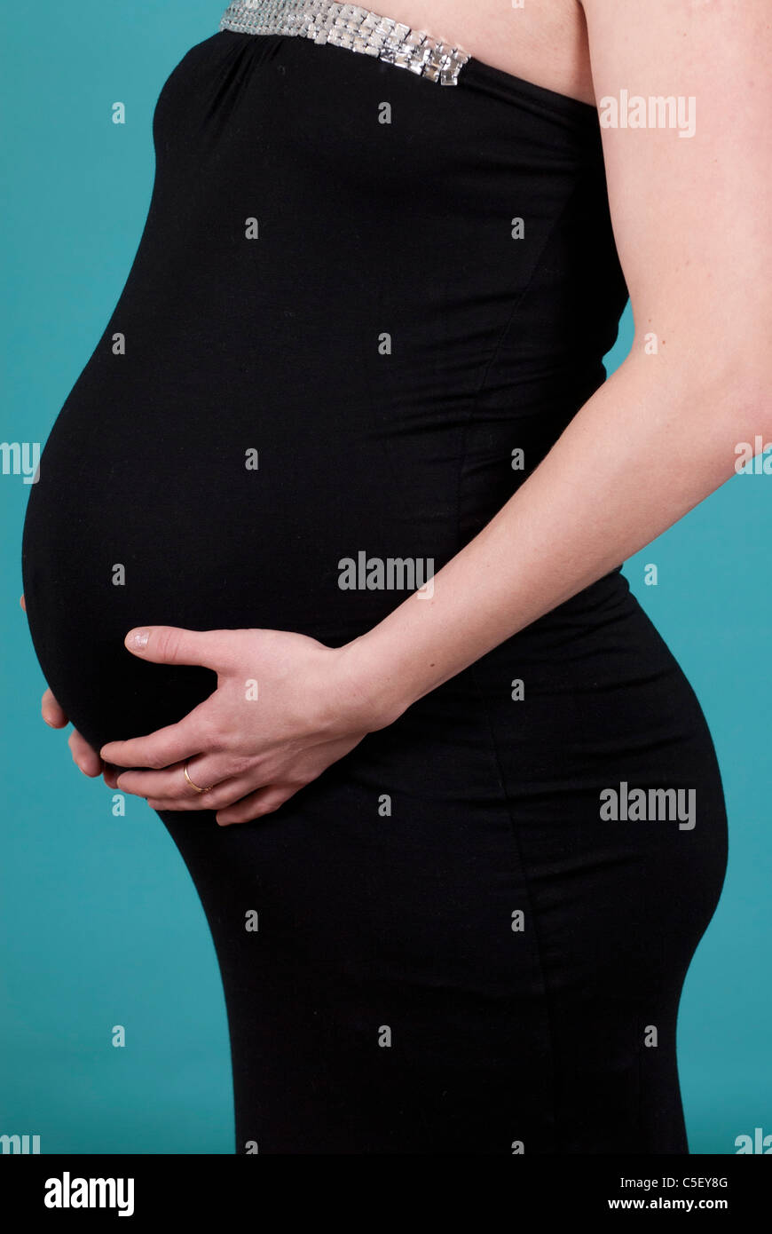 Pregnant woman holding her belly Stock Photo - Alamy