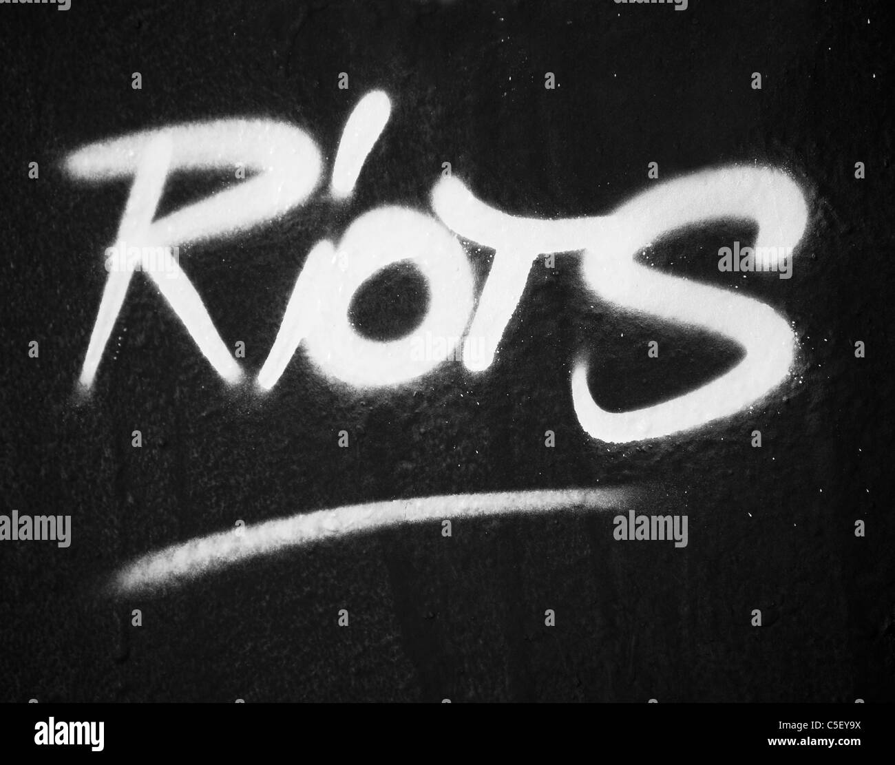 Riots text sprayed on a wall Stock Photo