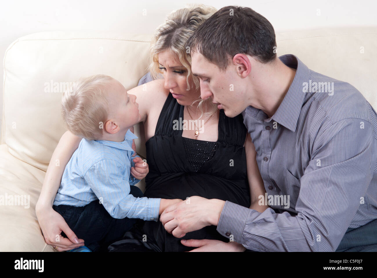 Pregnant woman and man talking to their toddler son Stock Photo