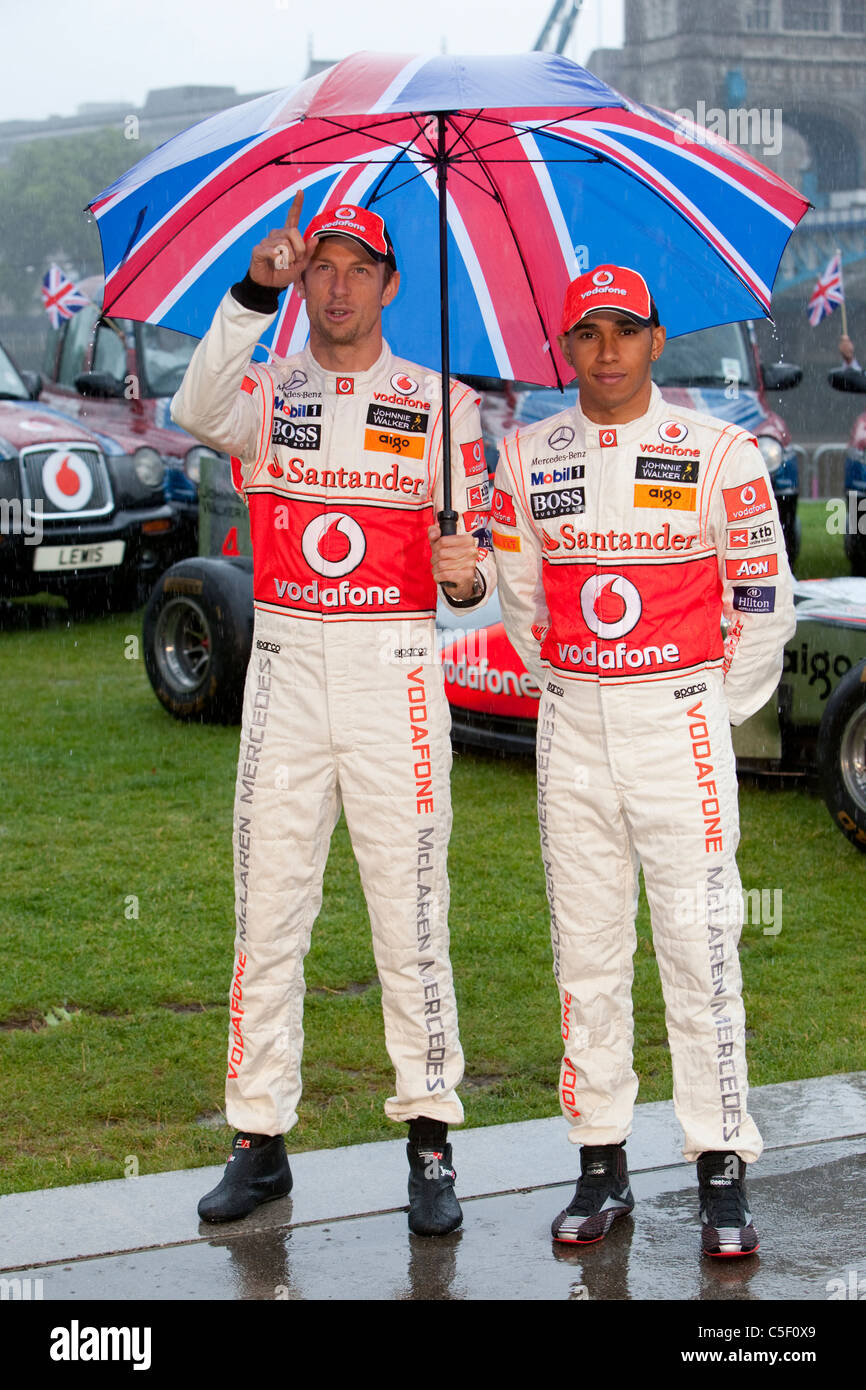 Former Formula 1 world champions Jenson Button and Lewis Hamilton attend a photocall in the pouring rain in London Stock Photo