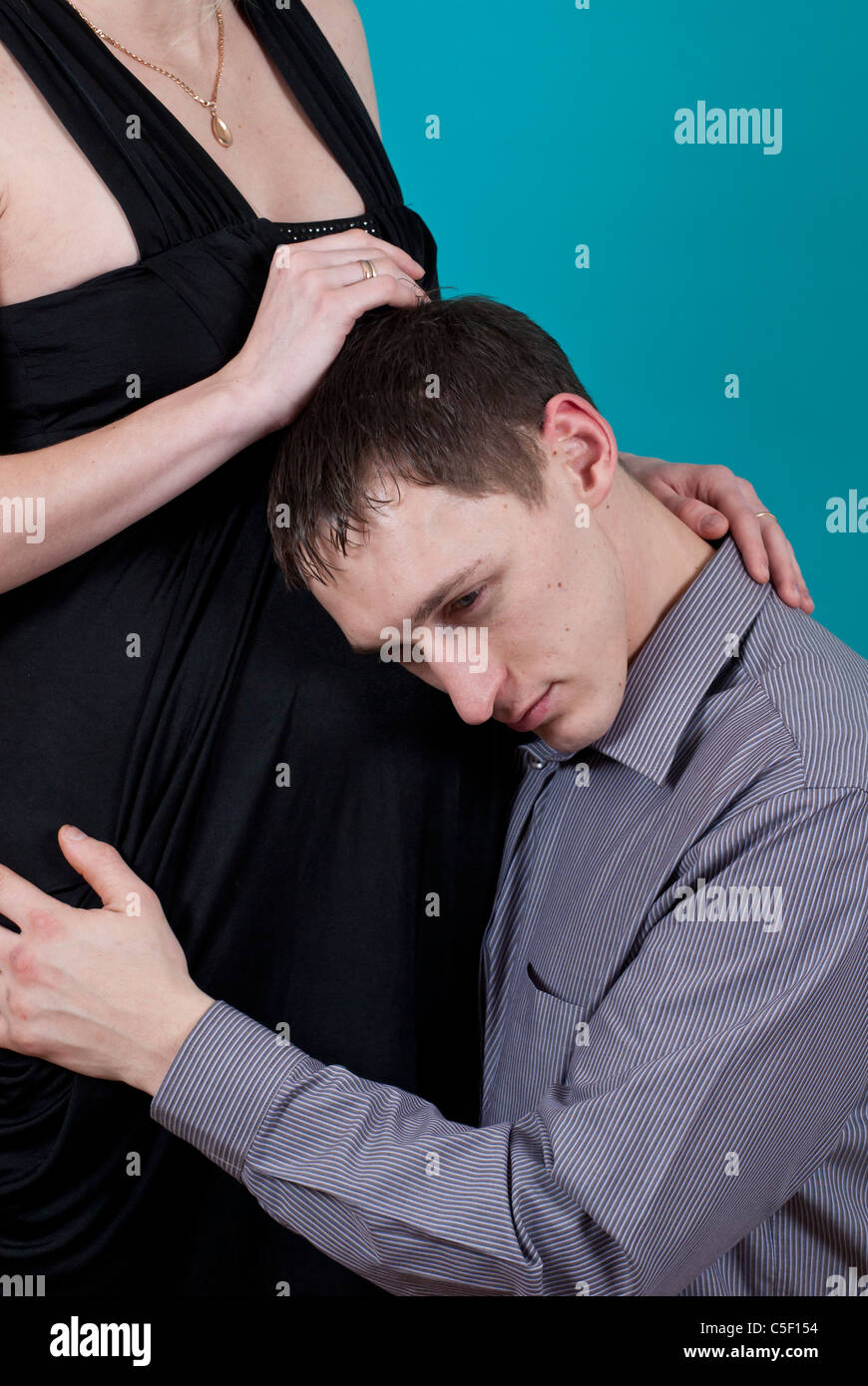 Man listening to a pregnant woman's belly Stock Photo - Alamy
