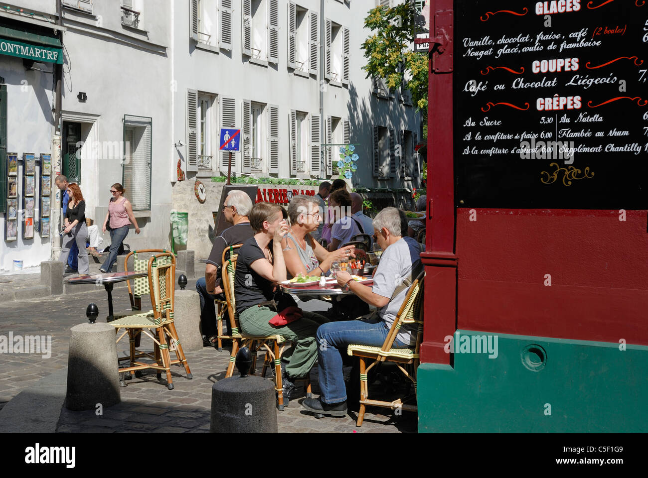 People sitting outdoors at Cafe Le Consulat Rue Norvins in the popular district of Montmartre, Paris France Stock Photo
