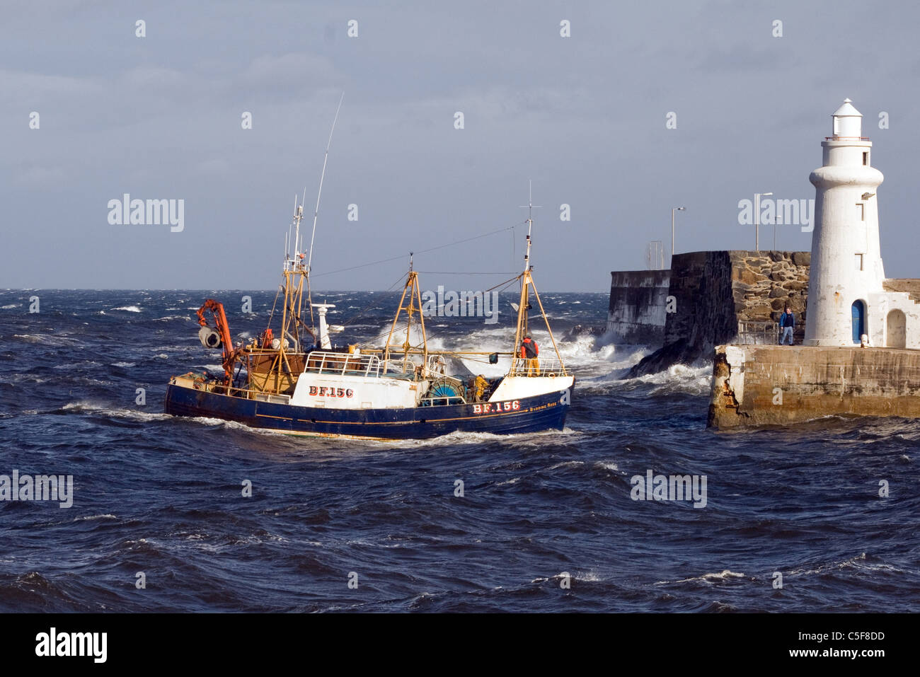 Fishing boat entering port Stock Photo - Alamy