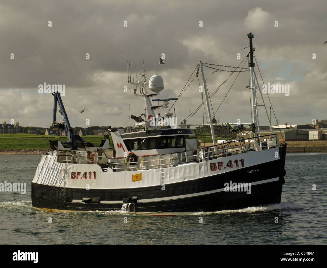 Fishing boat entering port Stock Photo - Alamy