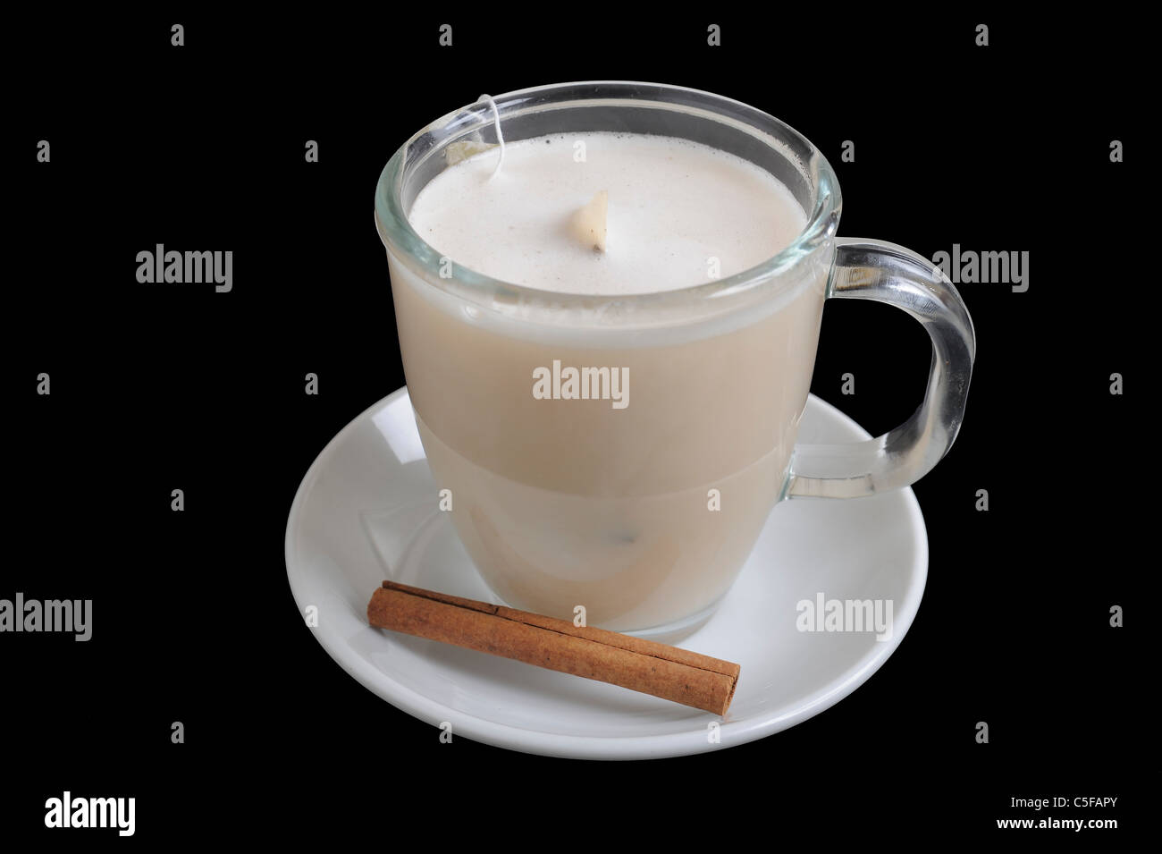 instant chai a cup of hot milk with teabag and cinnamon On black Background Stock Photo