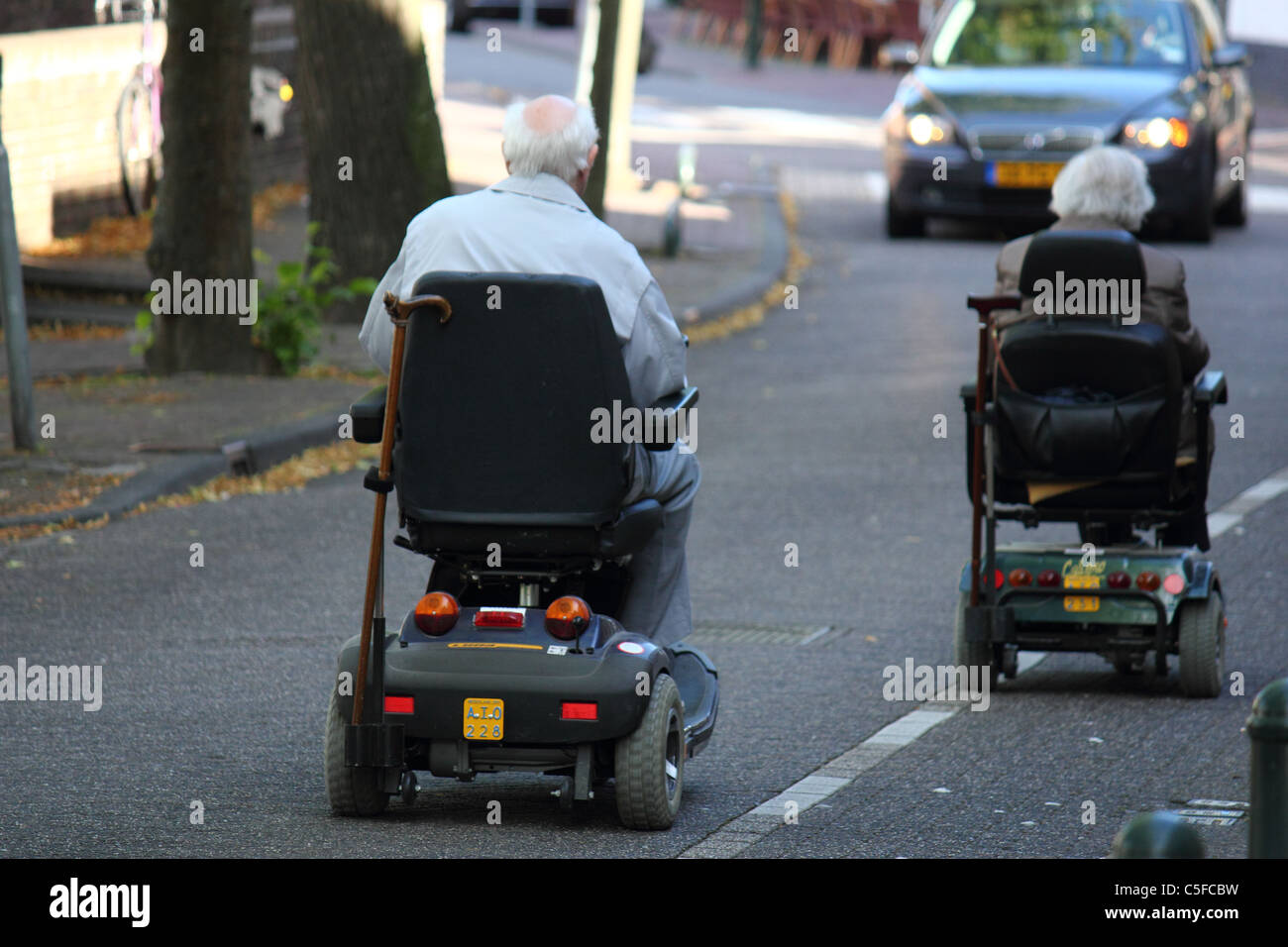 two elderly persons on a scooter trip in the city, conceptual image Stock Photo
