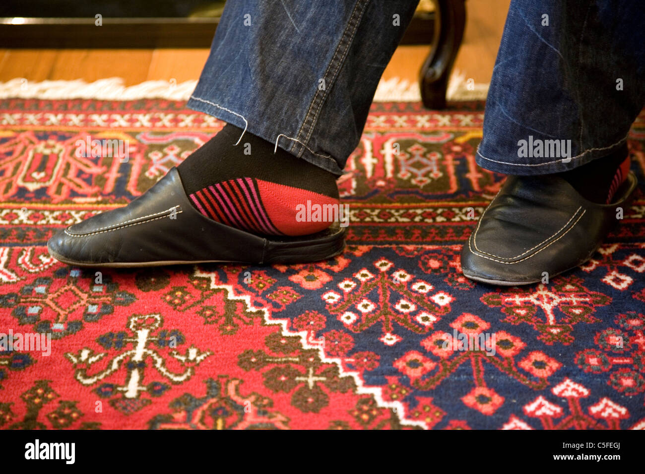 Man in wearing leather slippers on rug Stock Photo Alamy