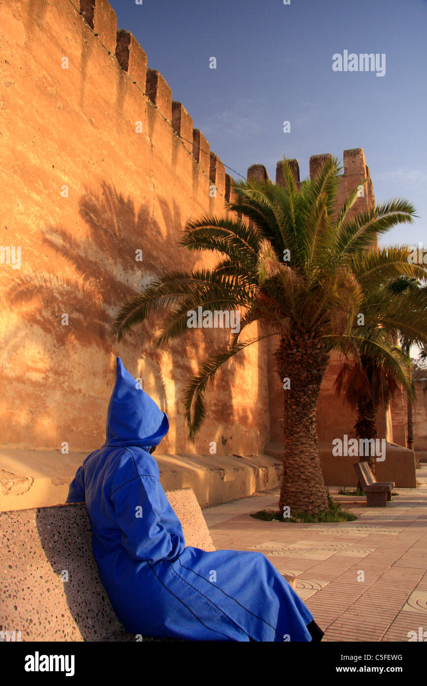 Person wearing Moroccan jellaba by the city walls in Taroudant; an unpretentious pre-Saharan market town, Sous Valley, Morocco Stock Photo