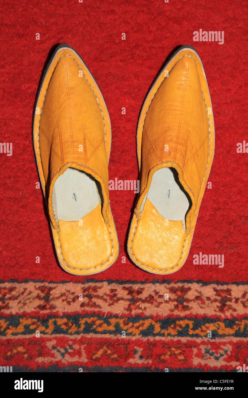 Traditional Moroccan shoes slippers footwear babouches against Moroccan carpet, Taroudant, Morocco Stock Photo