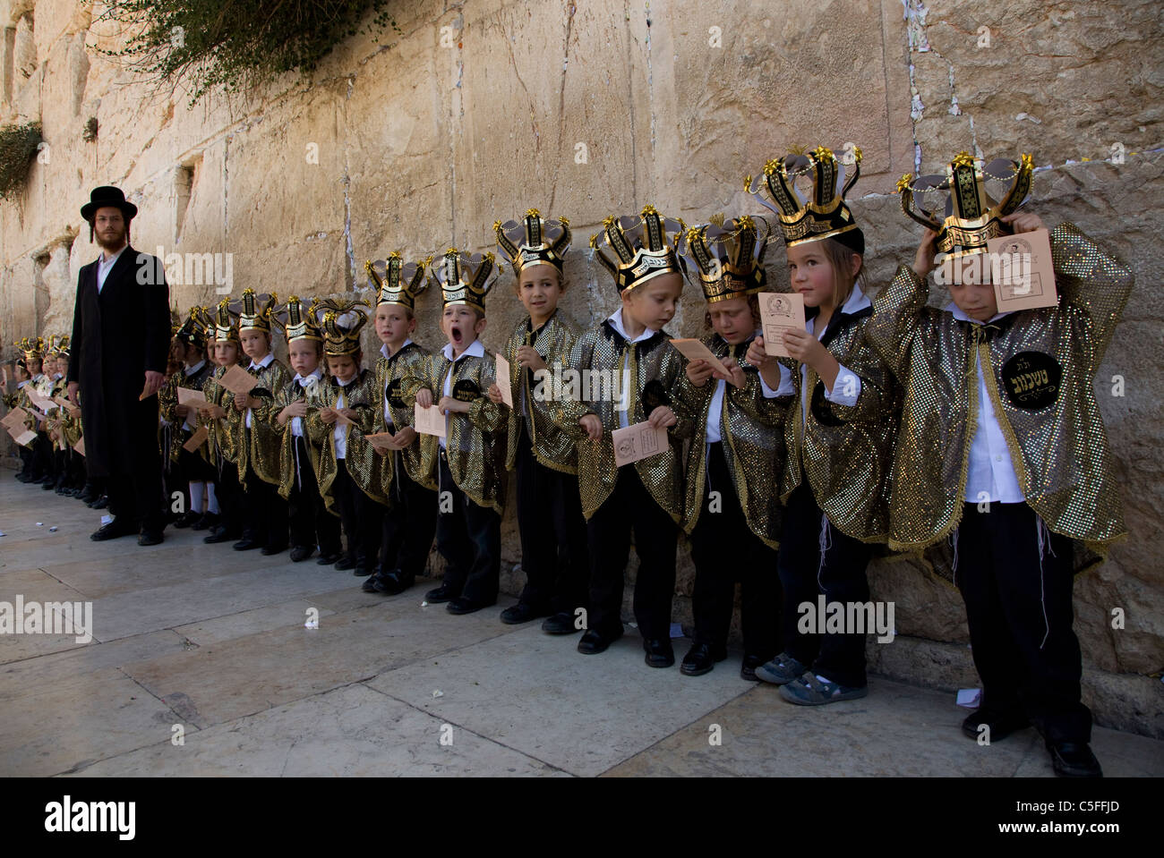 Ultra Orthodox children wearing Torah crowns during celebration of the Jewish holiday of Shavuot which marks the giving of the Torah at Mt. Sinai, seven weeks after the exodus of the Jewish people from Egypt. Western Wall Old city Jerusalem Israel Stock Photo