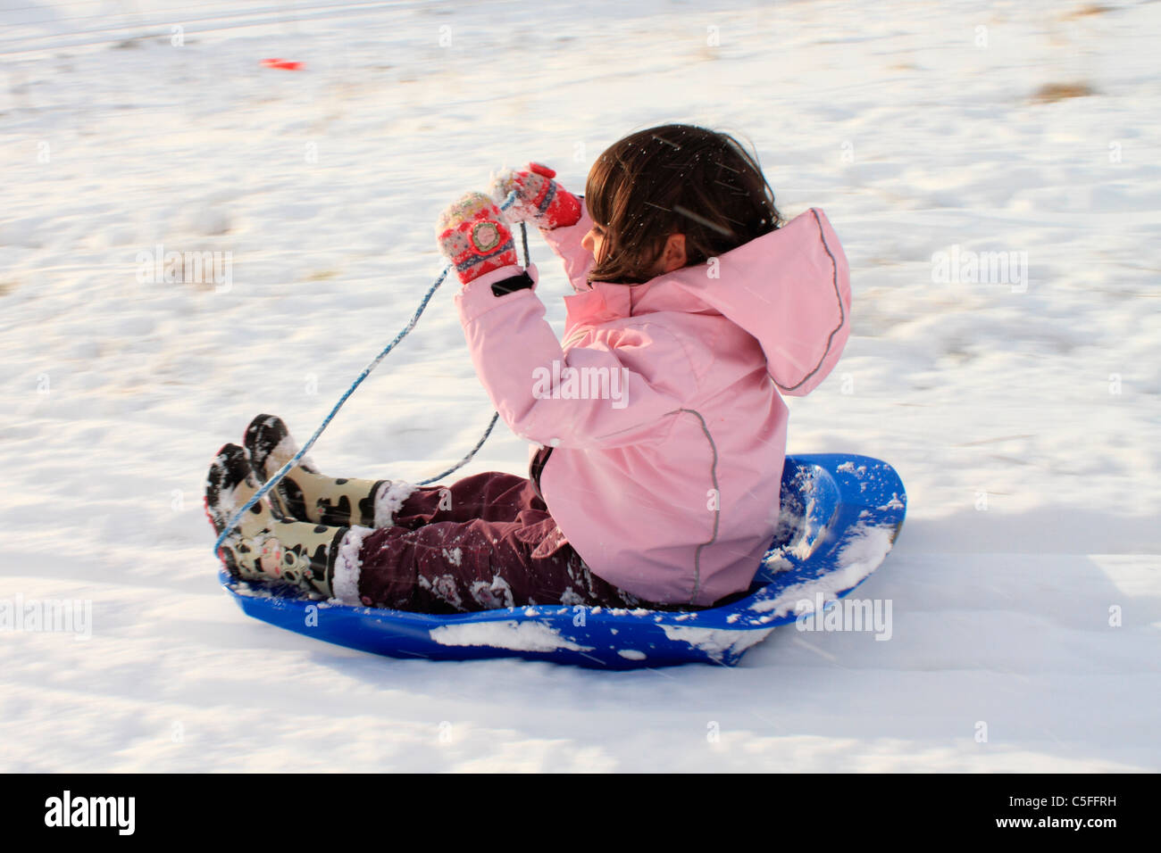 Young girl sledging Stock Photo
