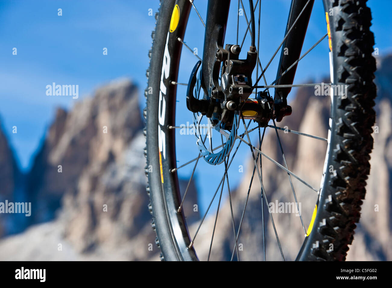 Mountain bike wheel in front of Tre Cime di Lavaredo in Sexten Dolomites, South Tyrol, Italy Stock Photo